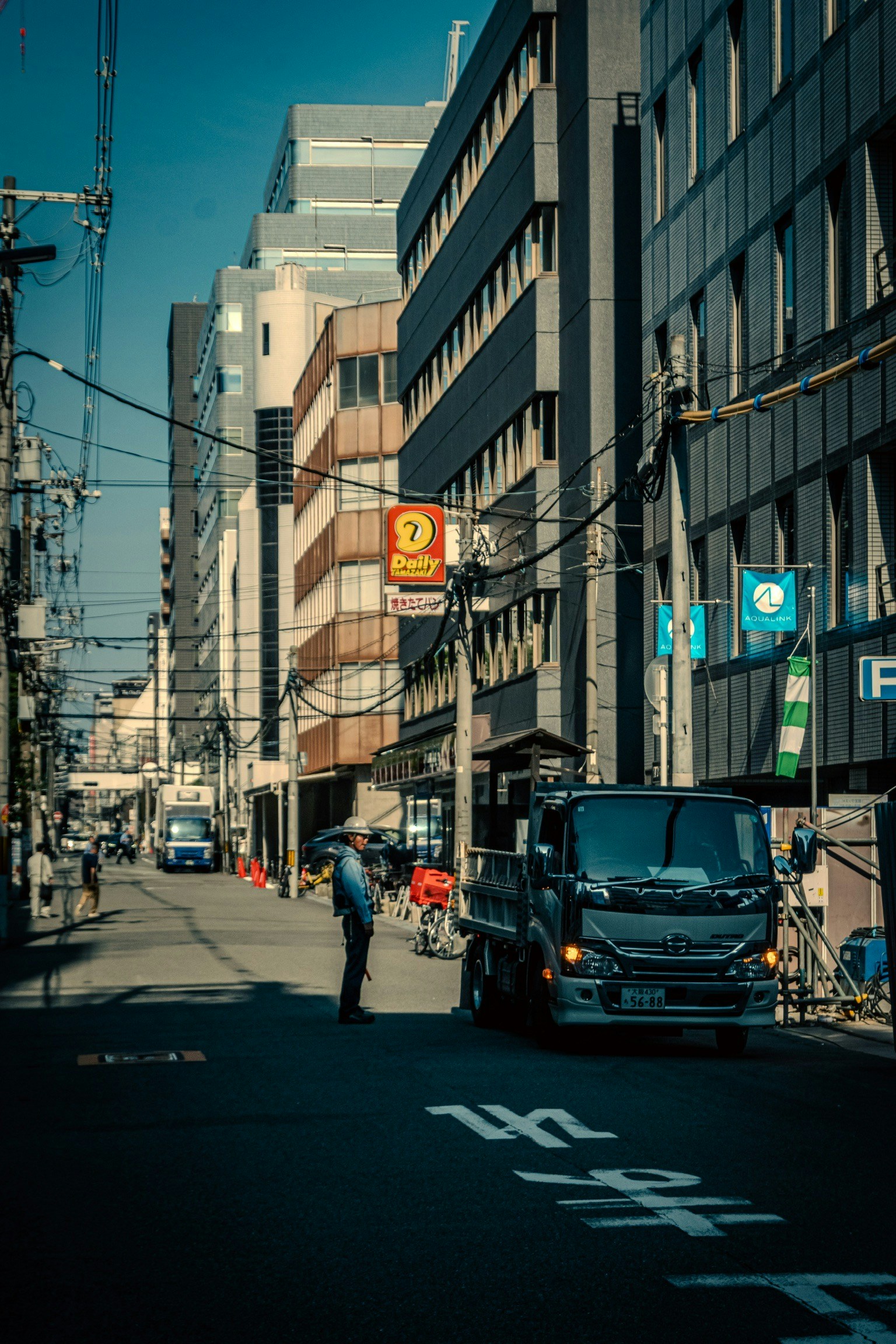 Eine Stadtstraße mit einem geparkten Lkw und einer stehenden Person