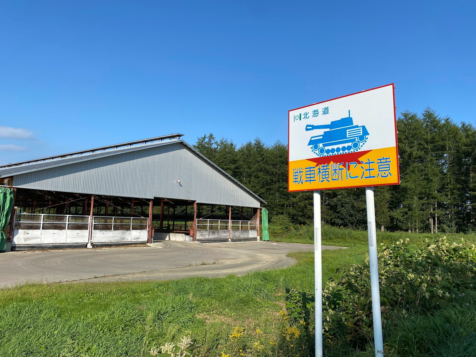 藍天之下有屋頂的建築和標誌上的坦克插圖