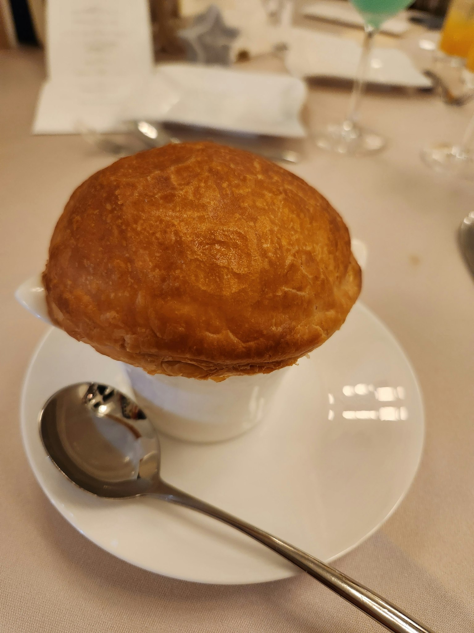 金黄色的舒芙蕾在白色杯子里配银勺