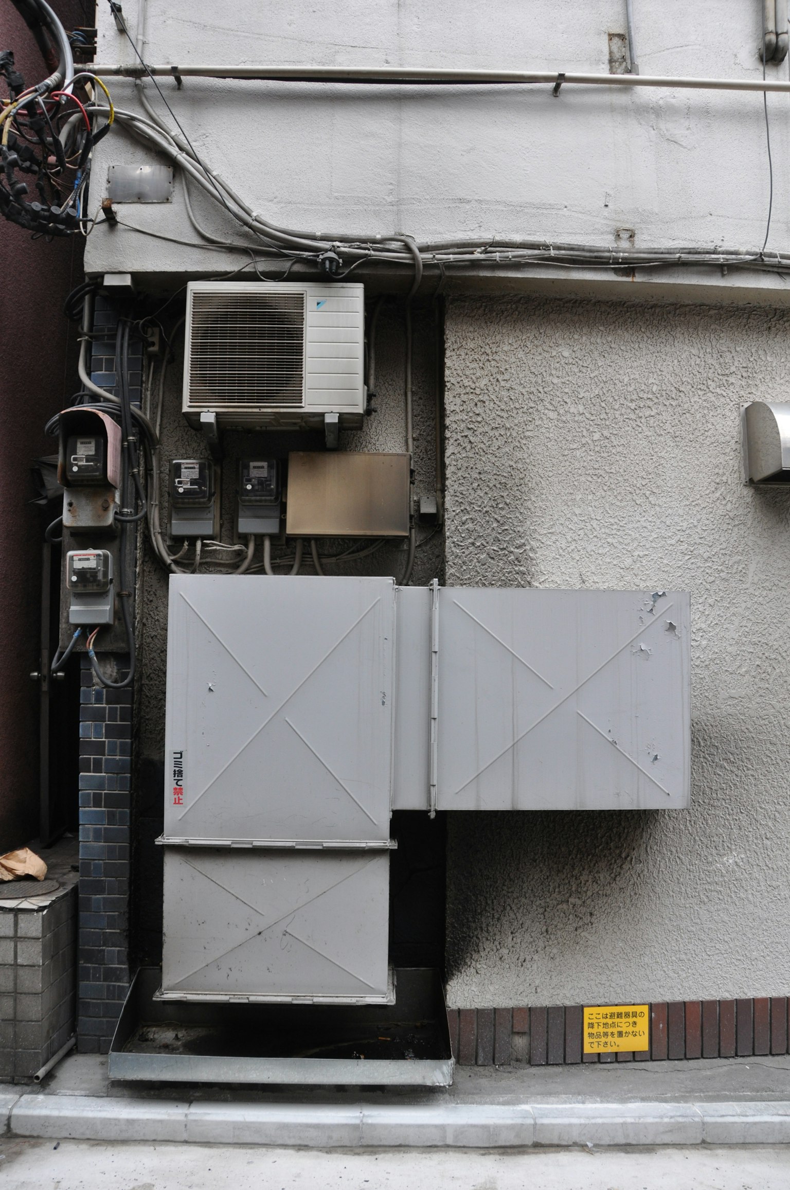 Conducto de ventilación gris y unidad de aire acondicionado montados en el exterior de un edificio
