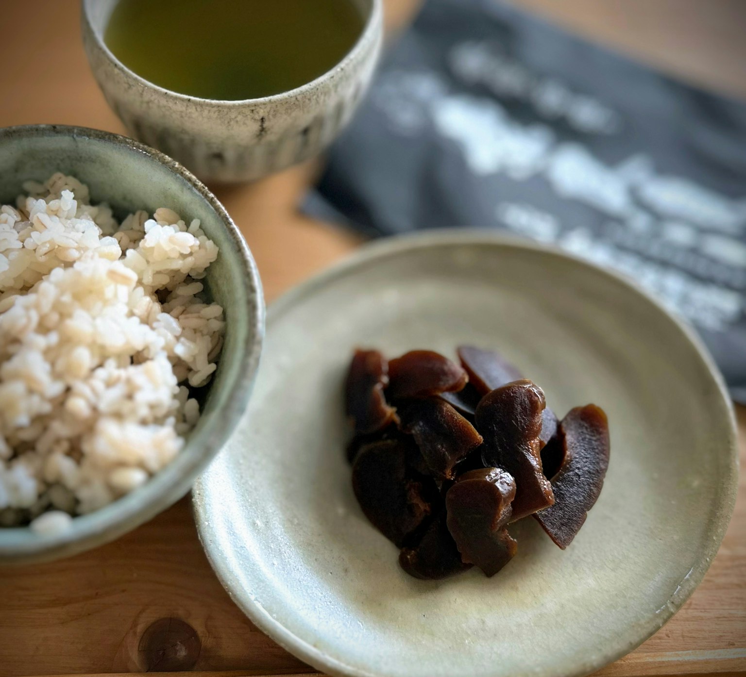 Japanisches Essen mit Reis in einer Schüssel und Pilzen auf einem Teller mit grünem Tee
