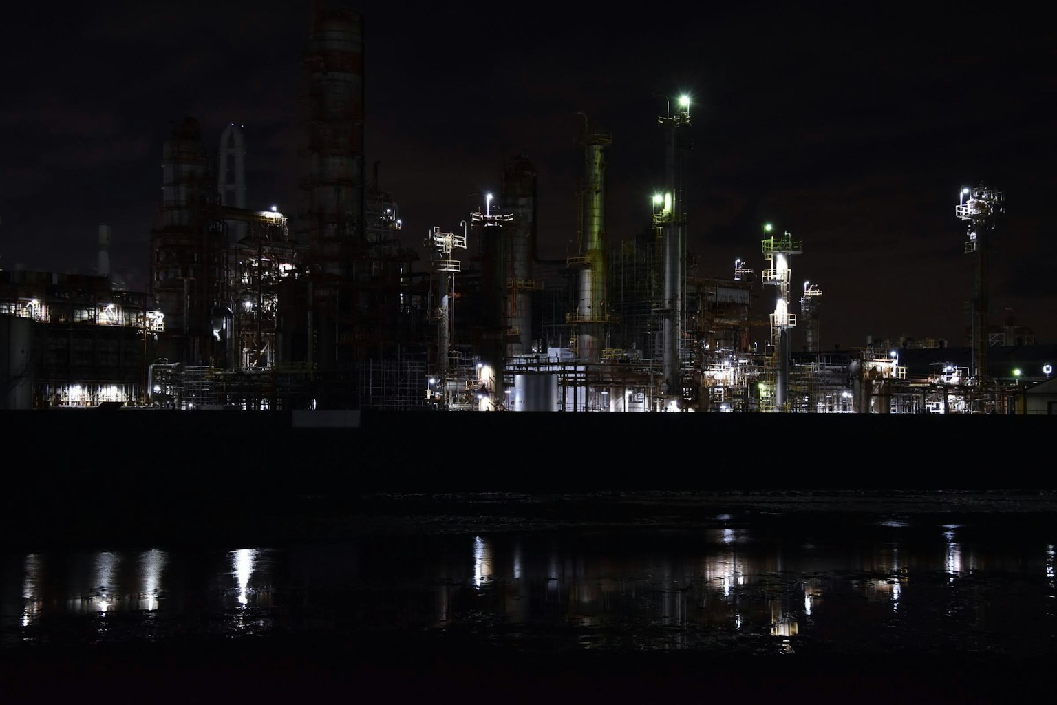 Night view of an industrial plant illuminated with reflections on water