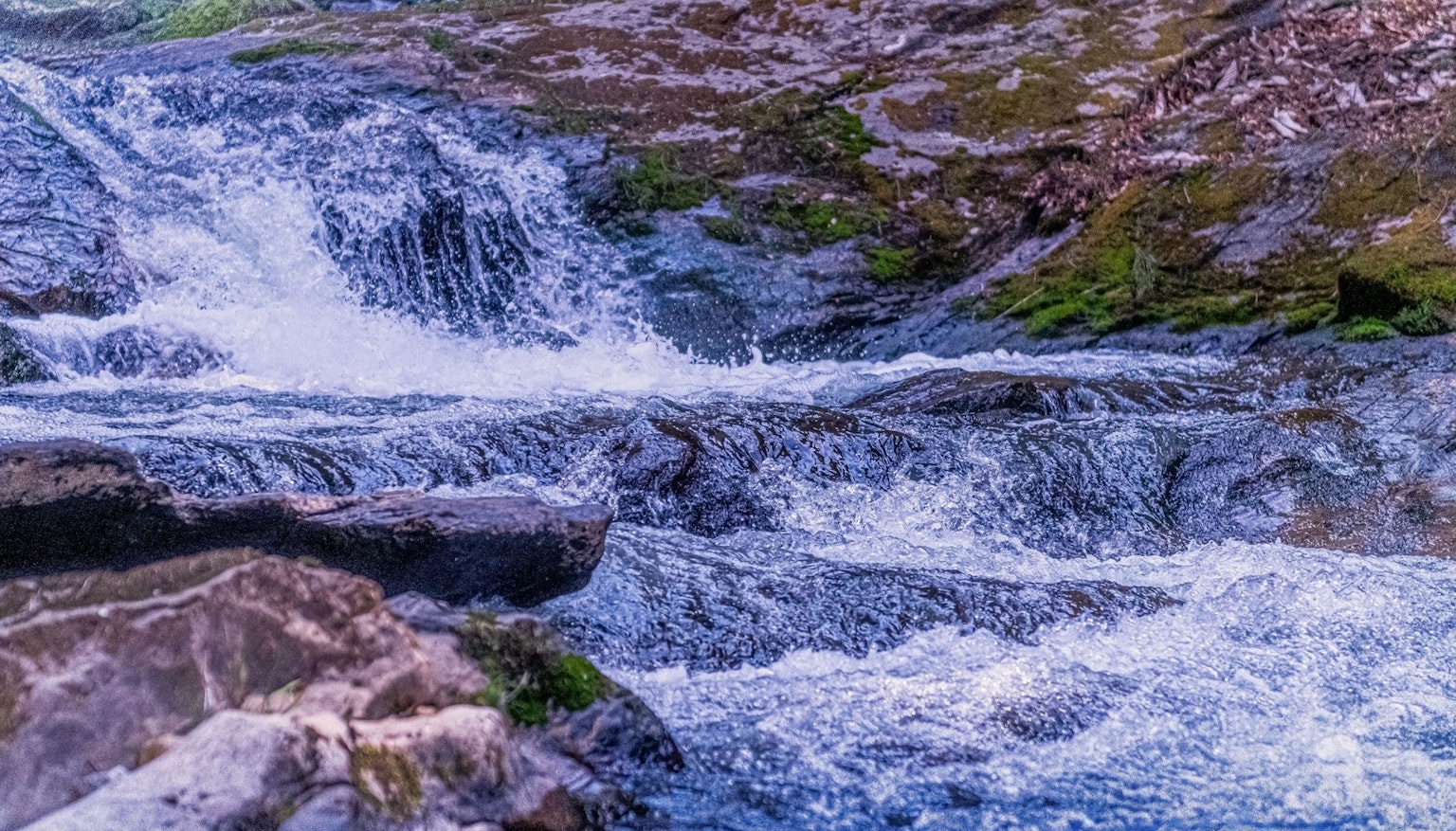 流动水和岩石的美丽景观 特色是绿色苔藓