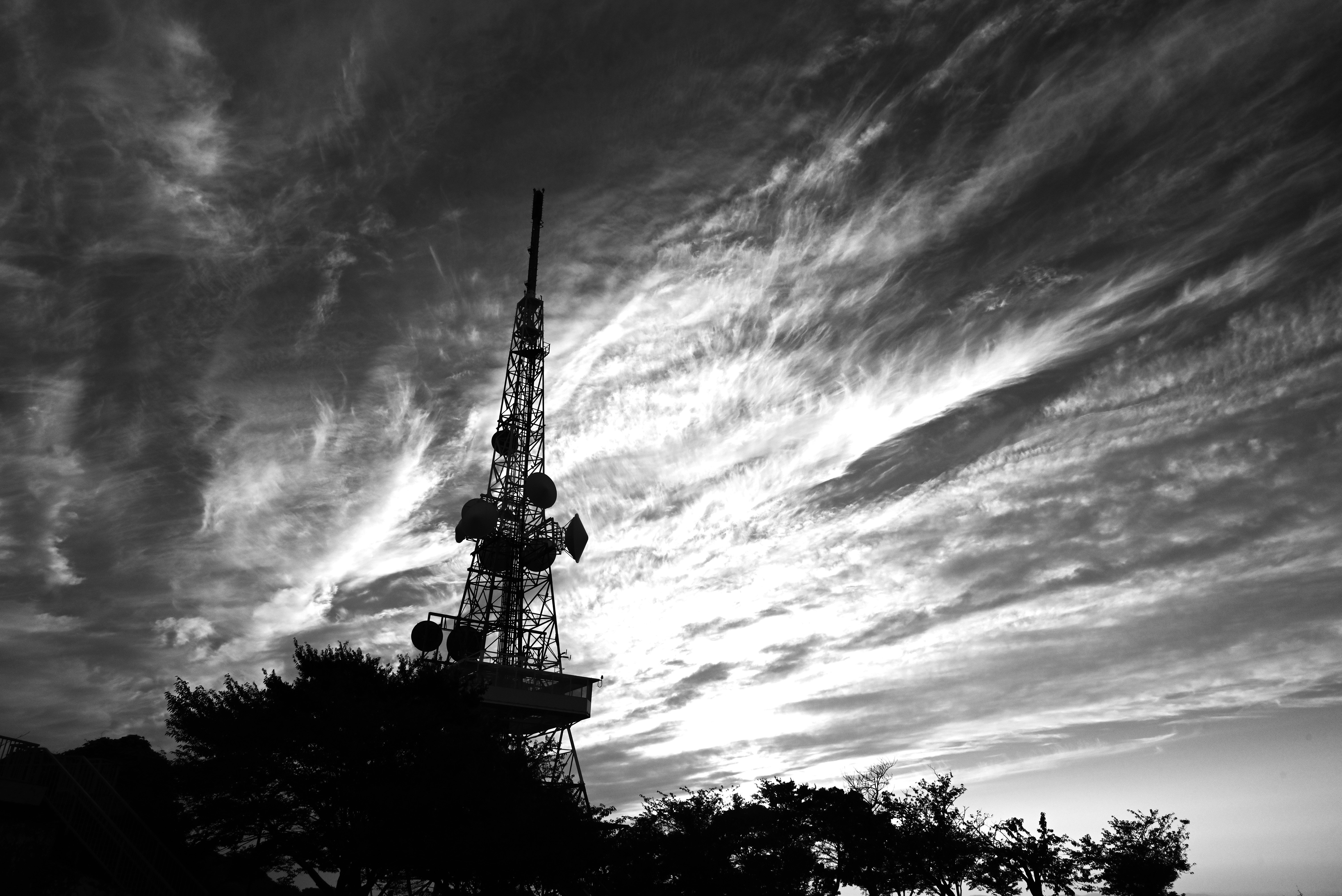 空にそびえる通信塔と雲のドラマチックな夕景