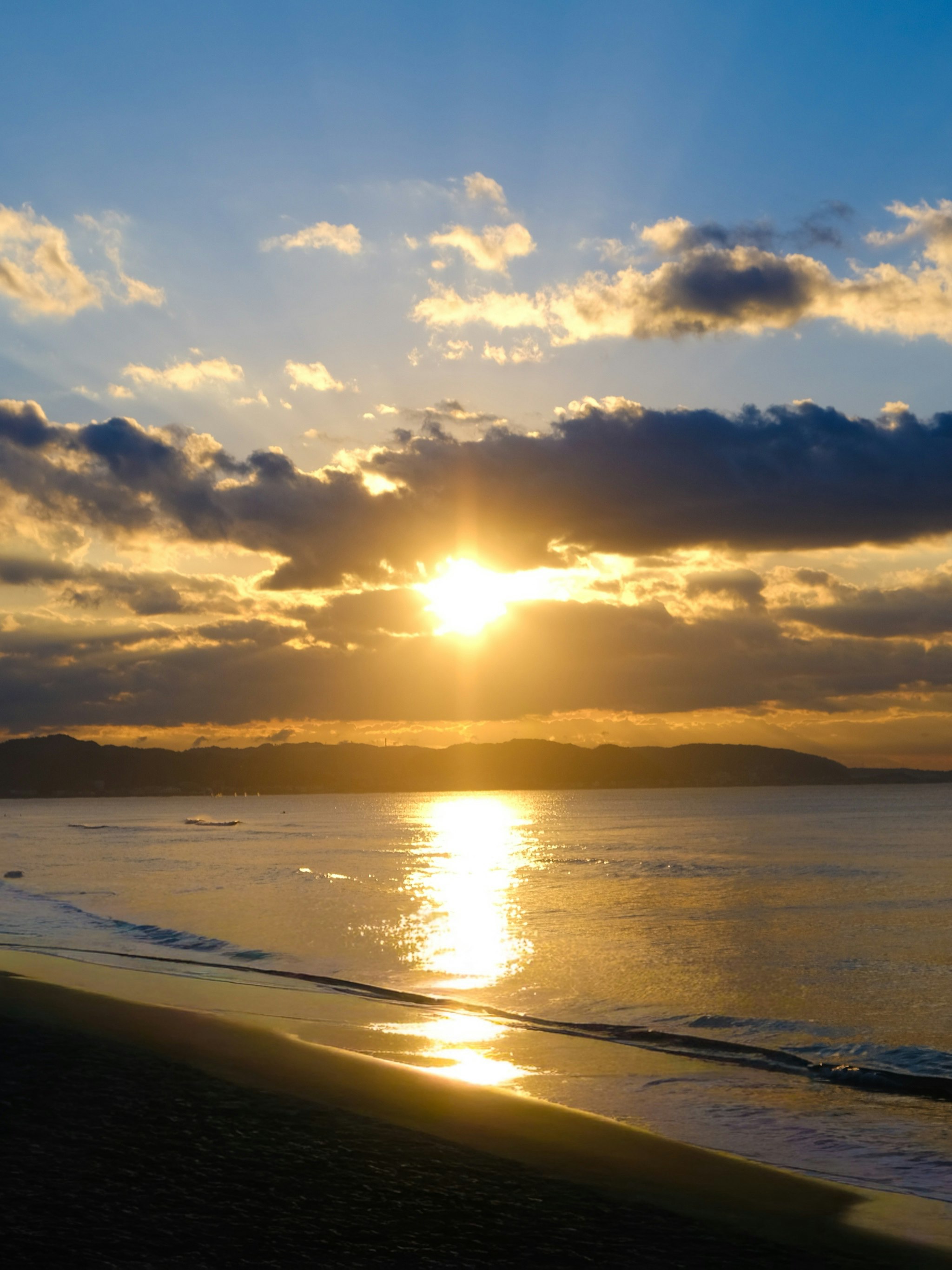 夕日に照らされた海辺の波と雲の空