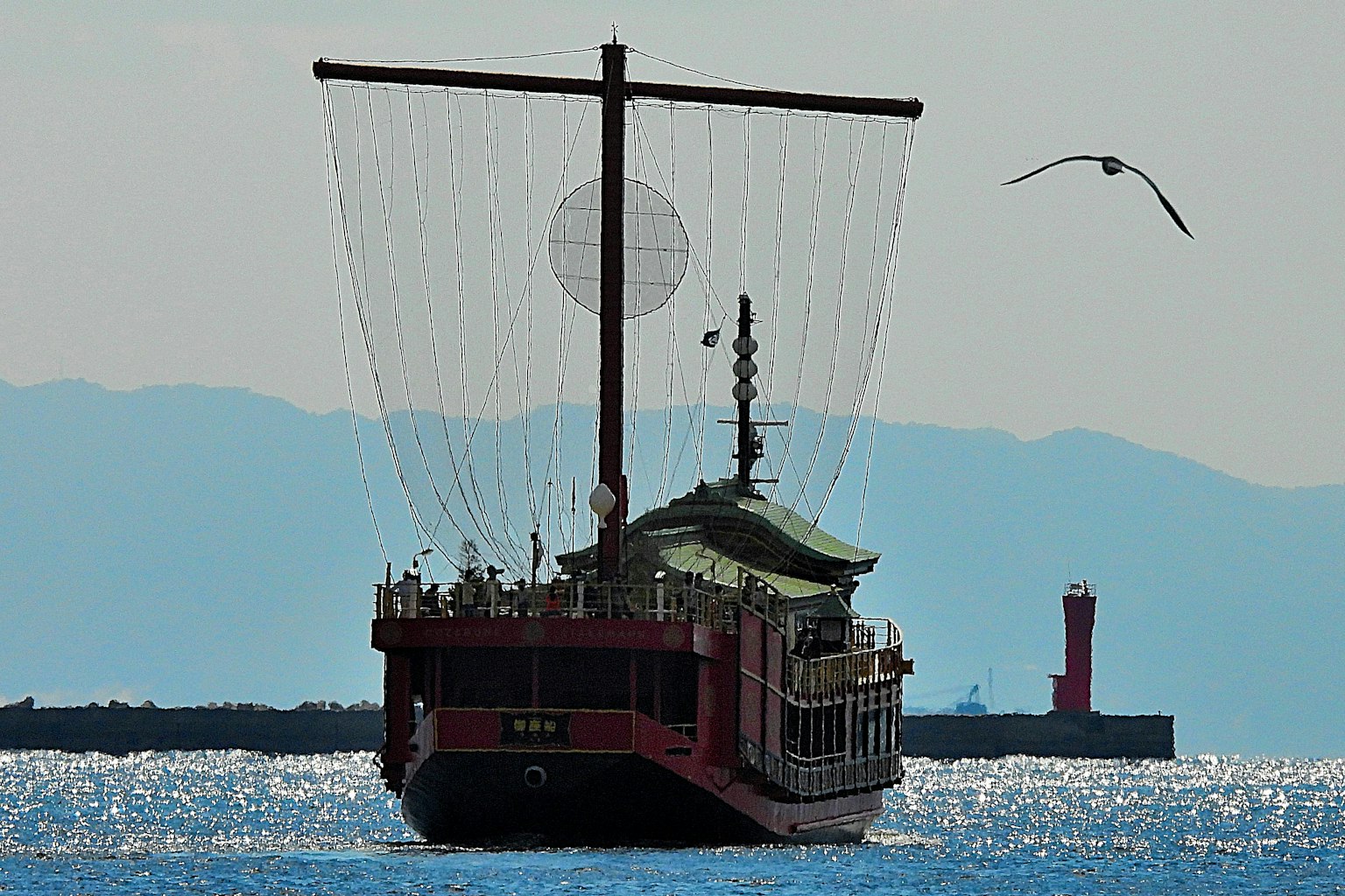 Bateau traditionnel naviguant sur l'eau avec des montagnes en arrière-plan