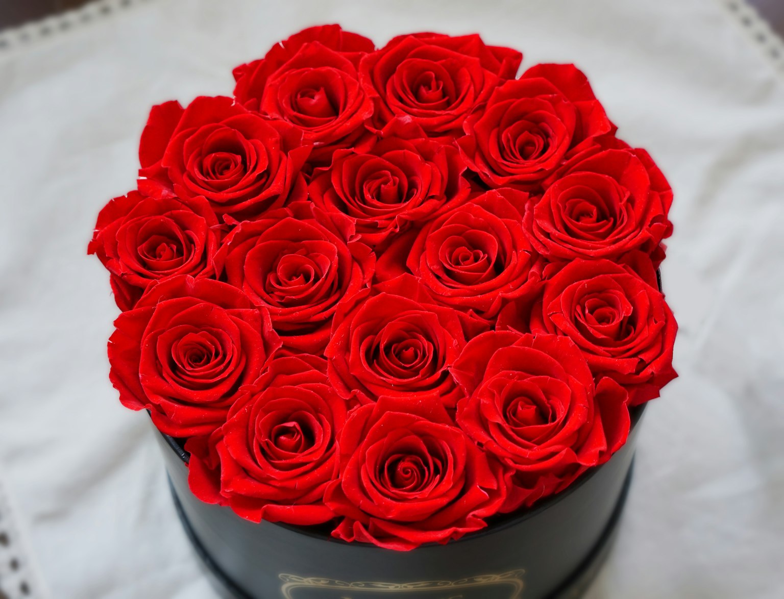 Un bouquet di rose rosse ordinatamente disposto in una scatola nera