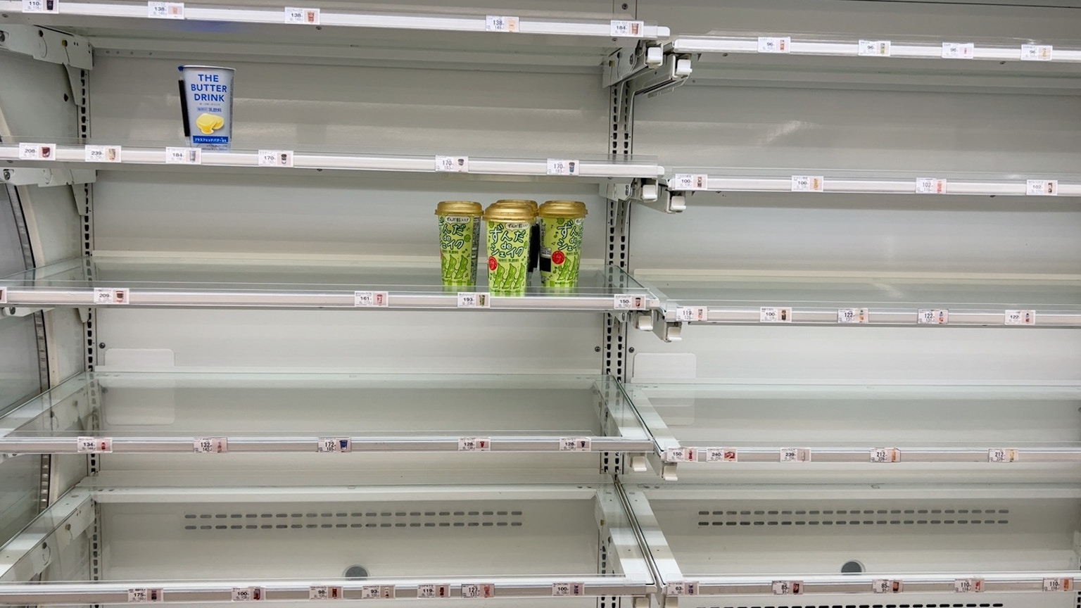 Kühlschrankregal mit Getränken und leeren Fächern