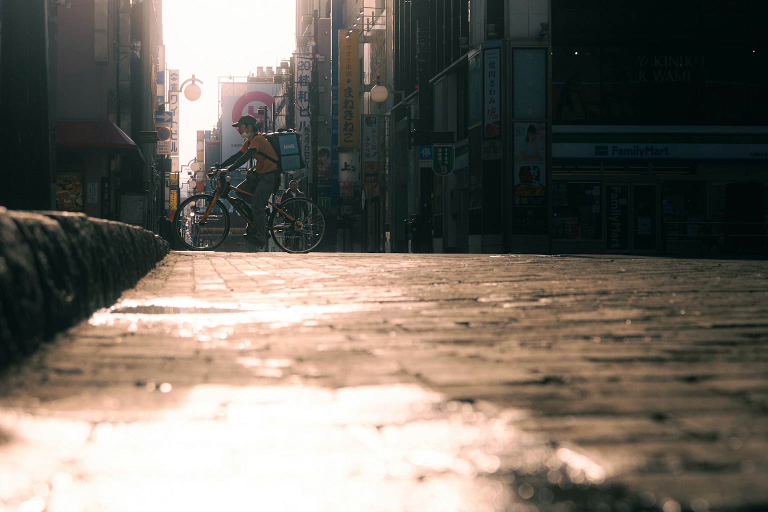 陽光照射下騎自行車穿過街道，路面反射