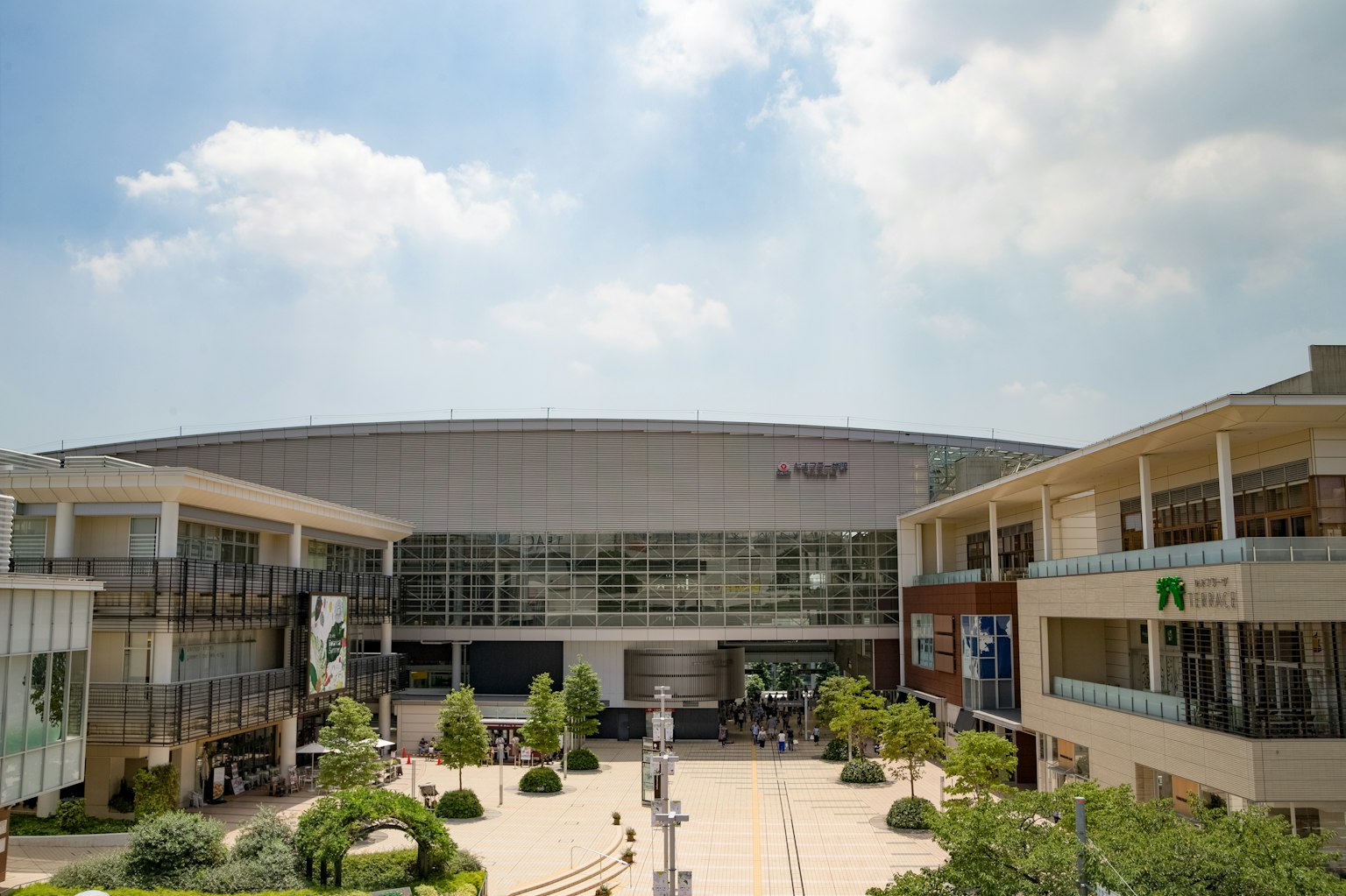 Spacious shopping mall exterior with bright blue sky