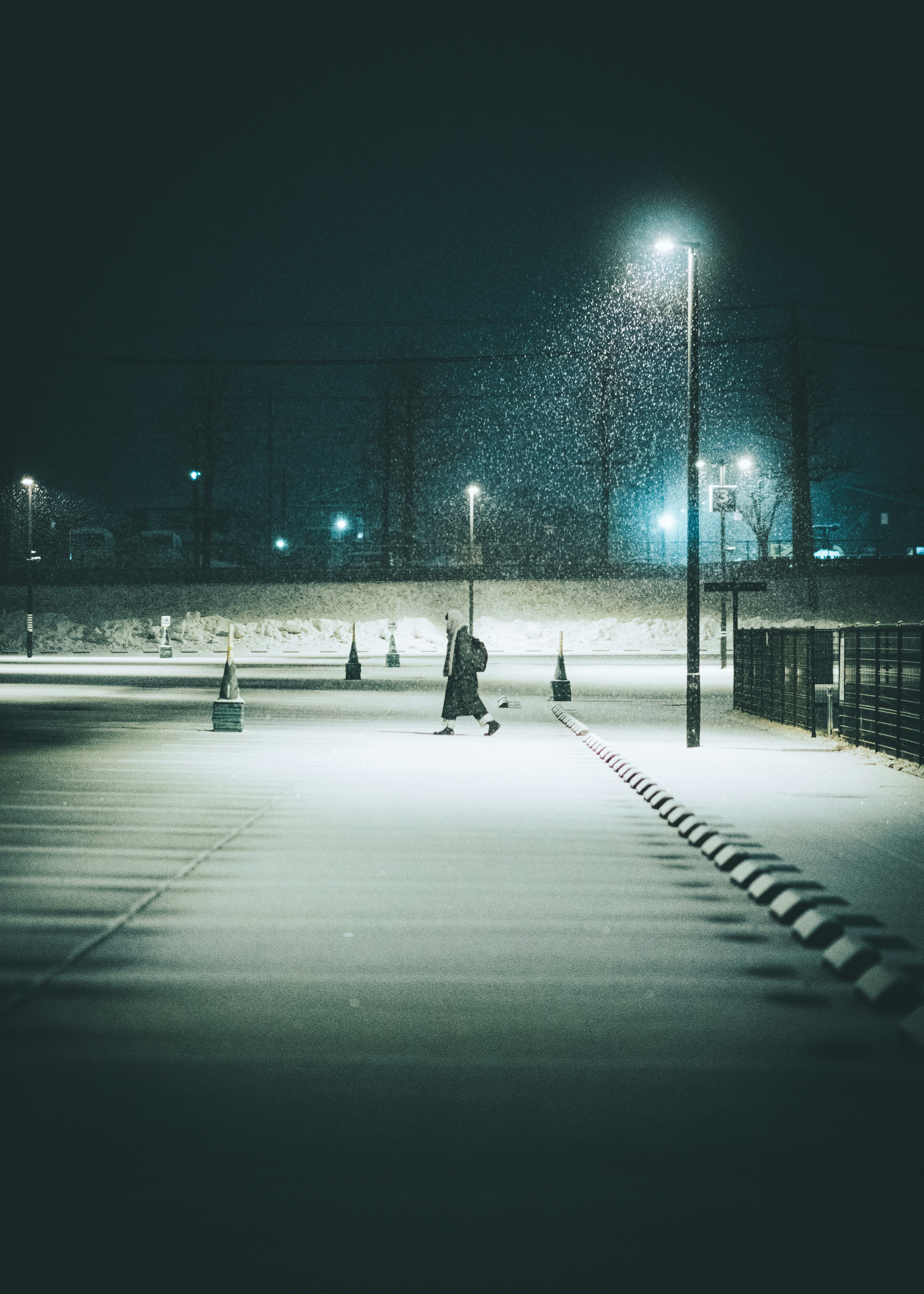 夜の雪道を照らす街灯と静かな歩道