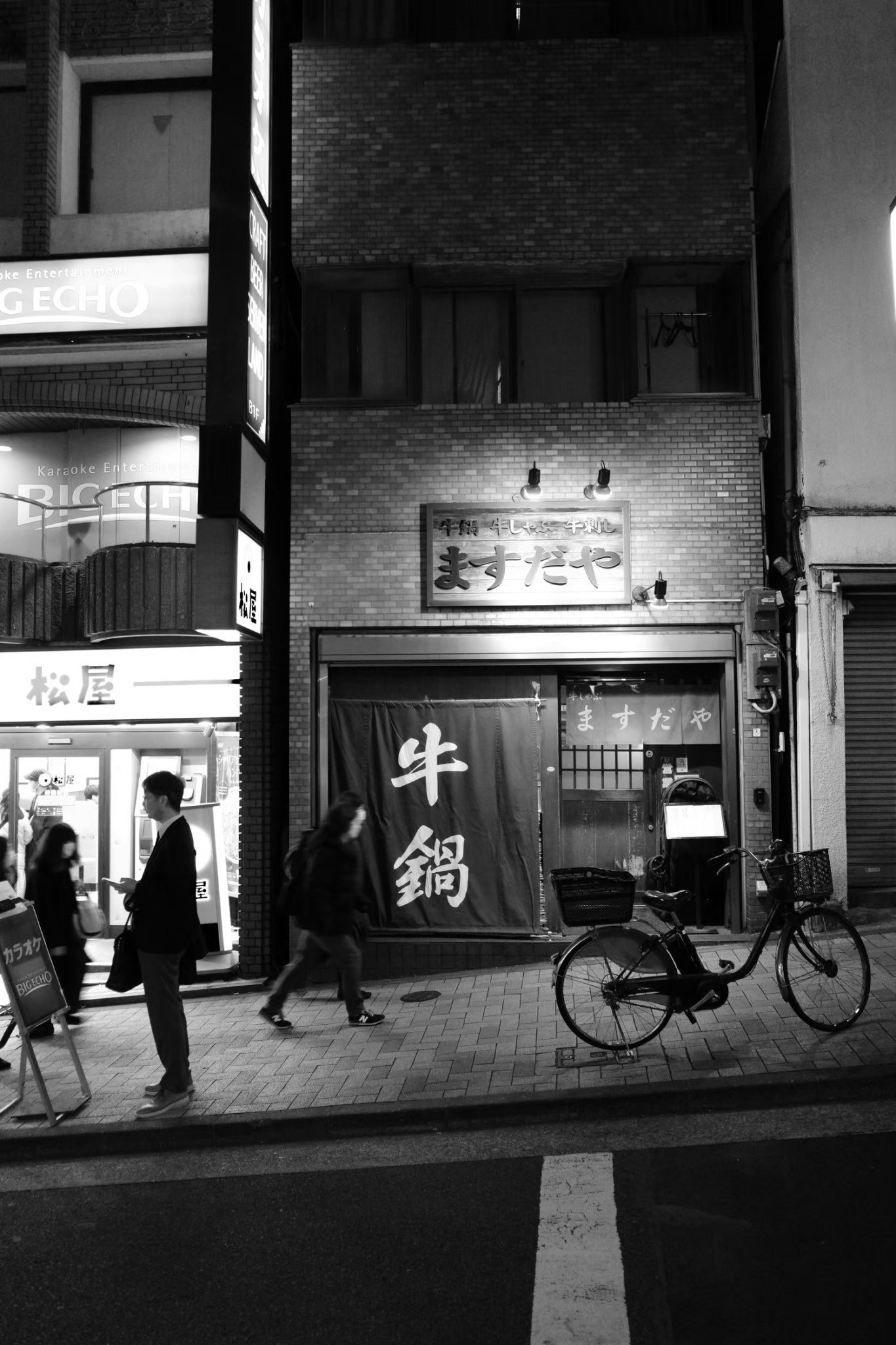 夜晚街道上店鋪招牌與自行車的場景