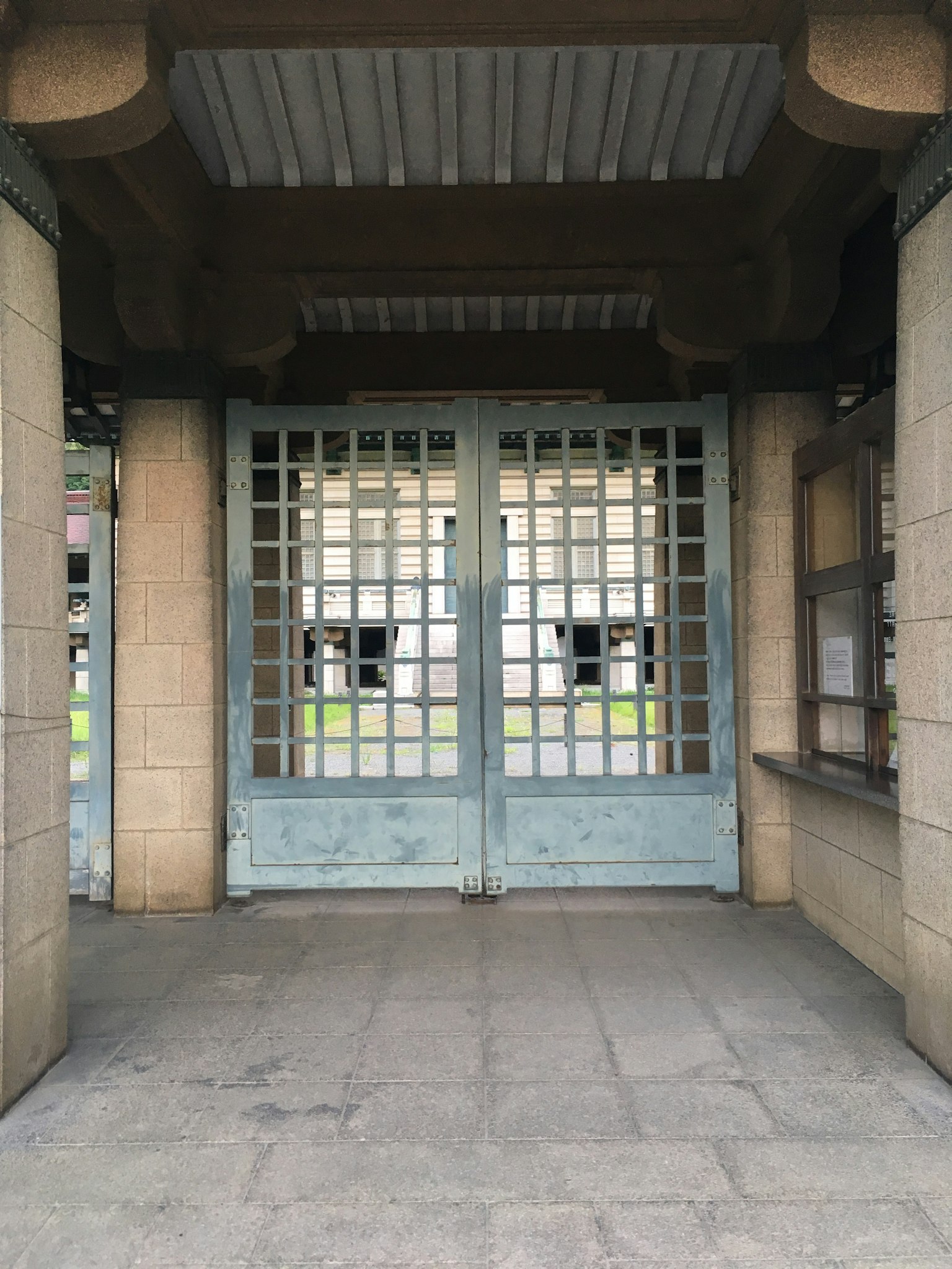 Pintu masuk dengan pintu kisi-kisi biru dan dinding batu