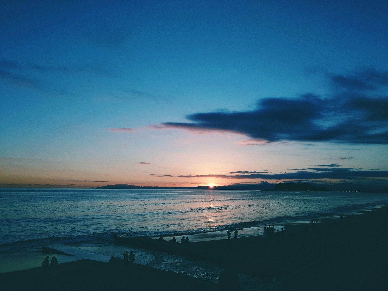 Schöne Landschaft des Sonnenuntergangs über dem Ozean mit einem ruhigen Strand
