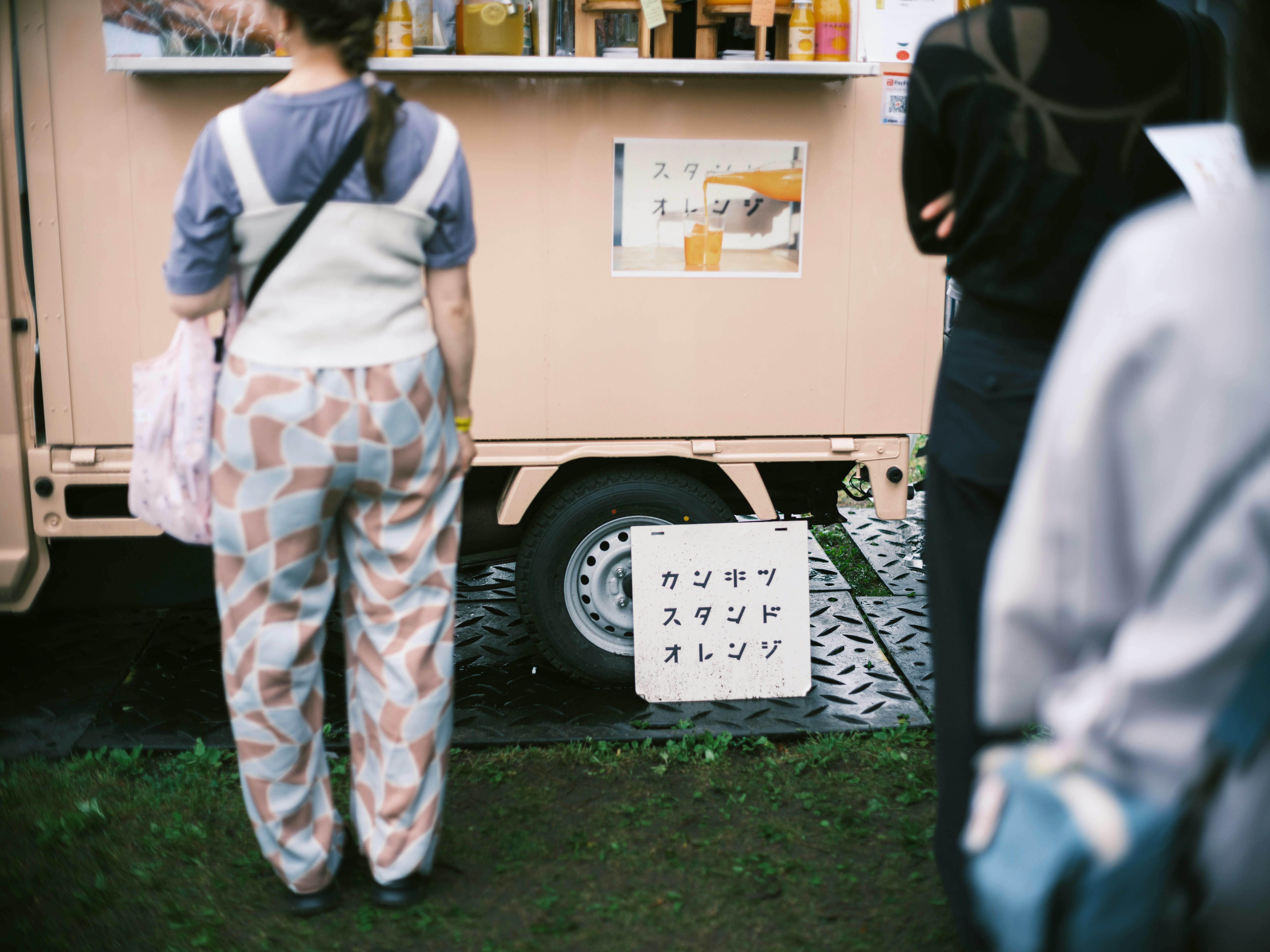 蚤の市の屋外で並ぶ子ども用の衣類と露店の看板