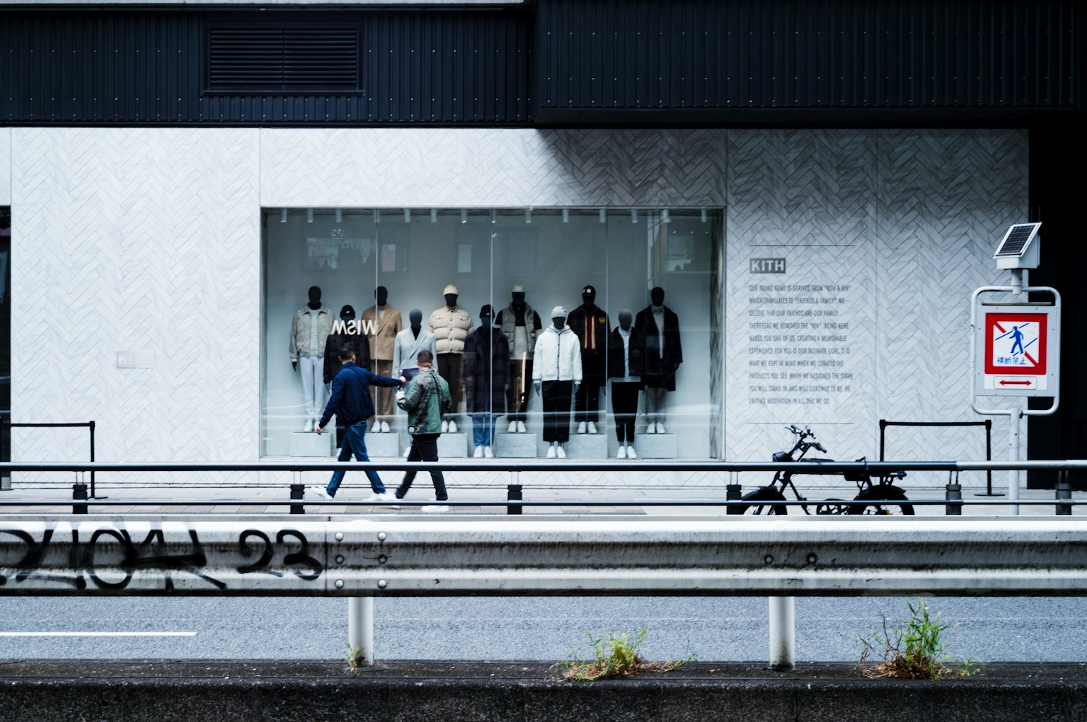 Vetrina con abbigliamento e pedoni che passano