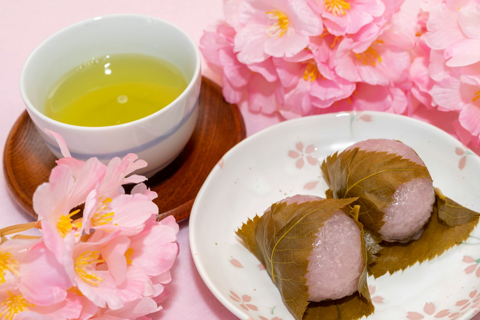 Una hermosa escena con flores de cerezo y dulces japoneses tradicionales acompañados de té verde