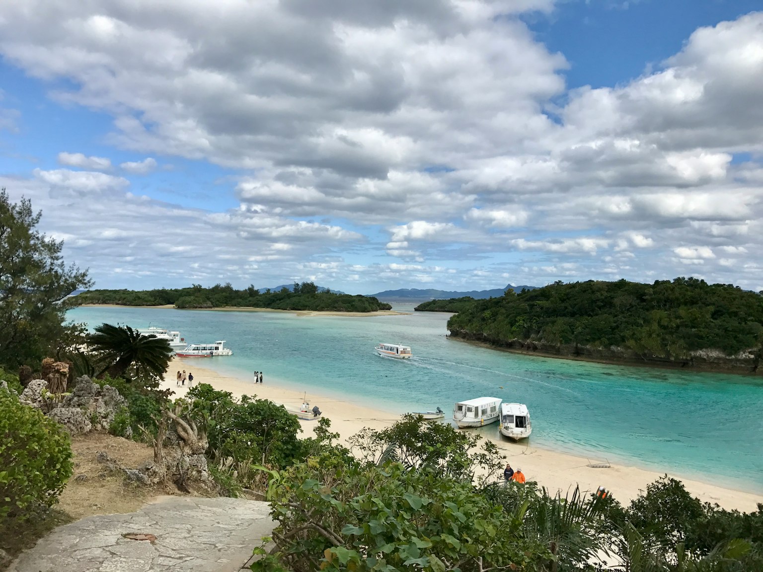 美麗的海灘景色，碧綠的水域和靠近郁郁蔥蔥島嶼的小船