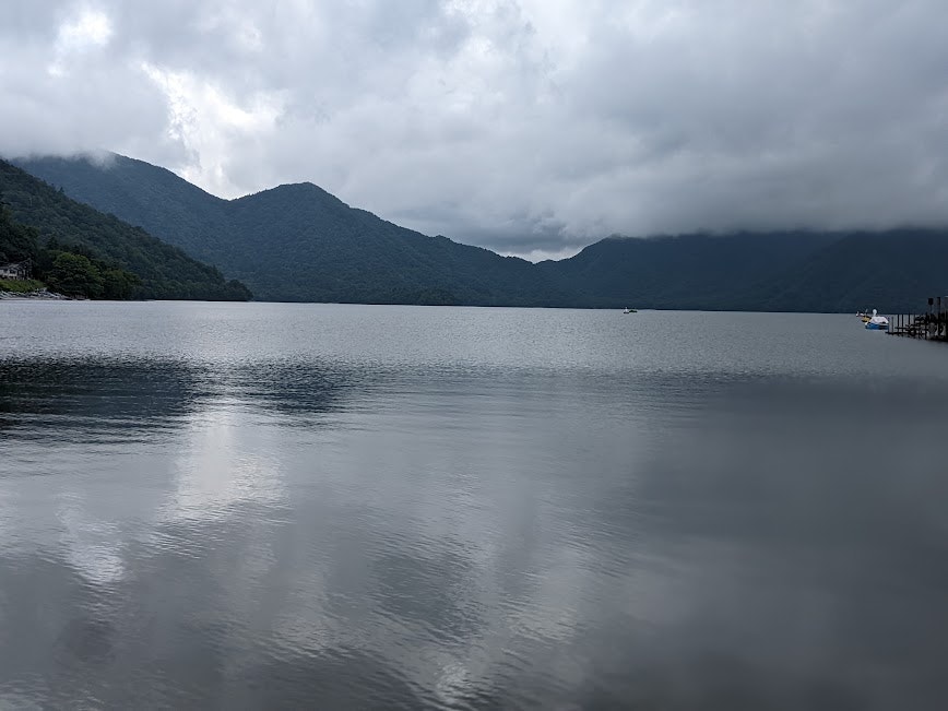 霧のかかった湖面と山並みの静かな景色