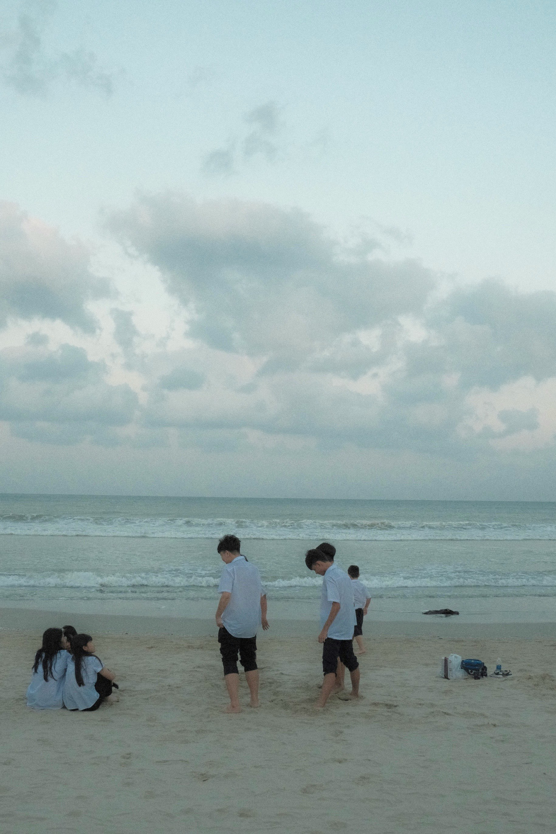 Kinder spielen am Strand mit einem ruhigen Meer im Hintergrund