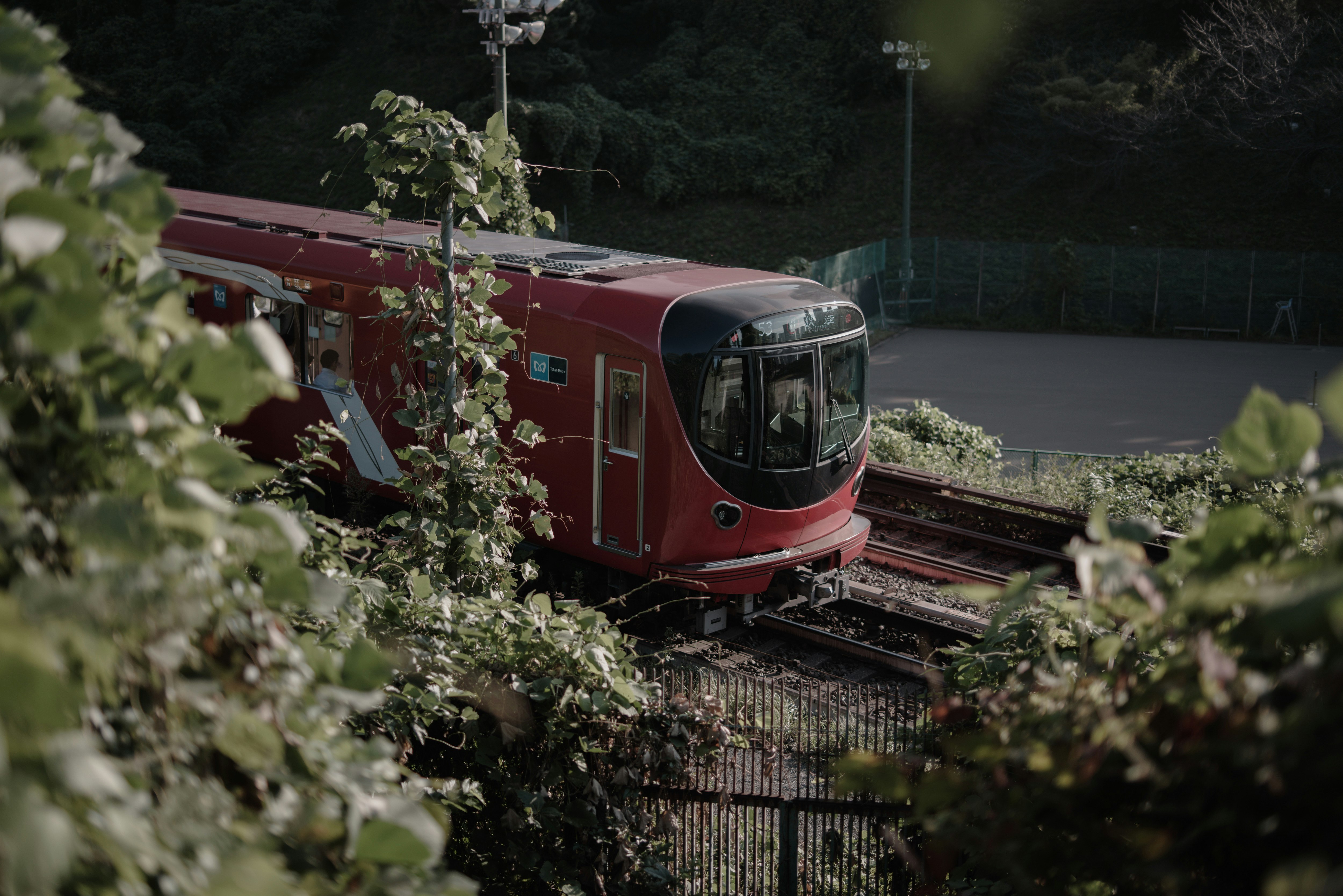 A red Marunouchi Line train running on tracks at night