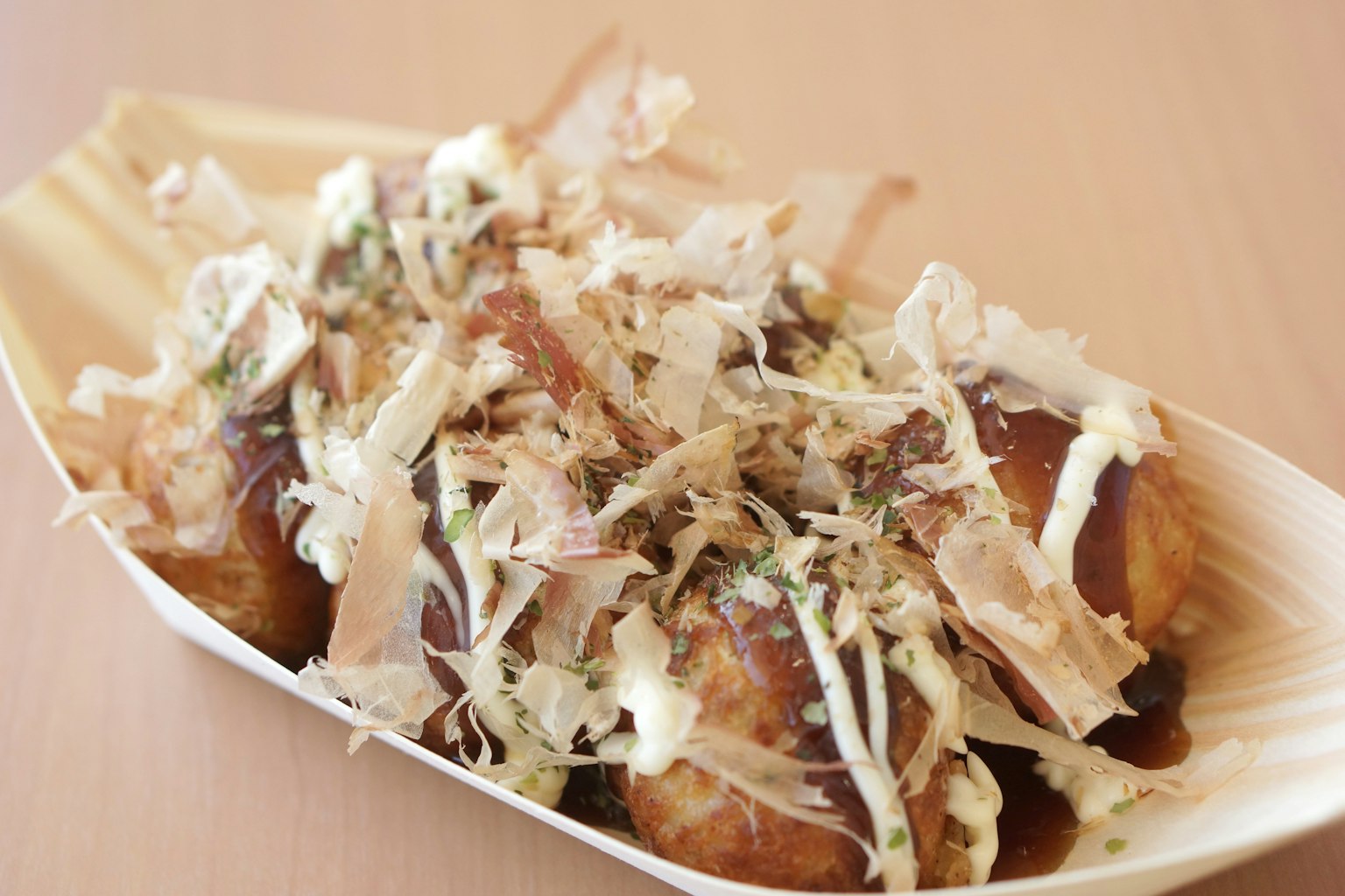 Photo de takoyaki servi sur une assiette en bois avec des garnitures