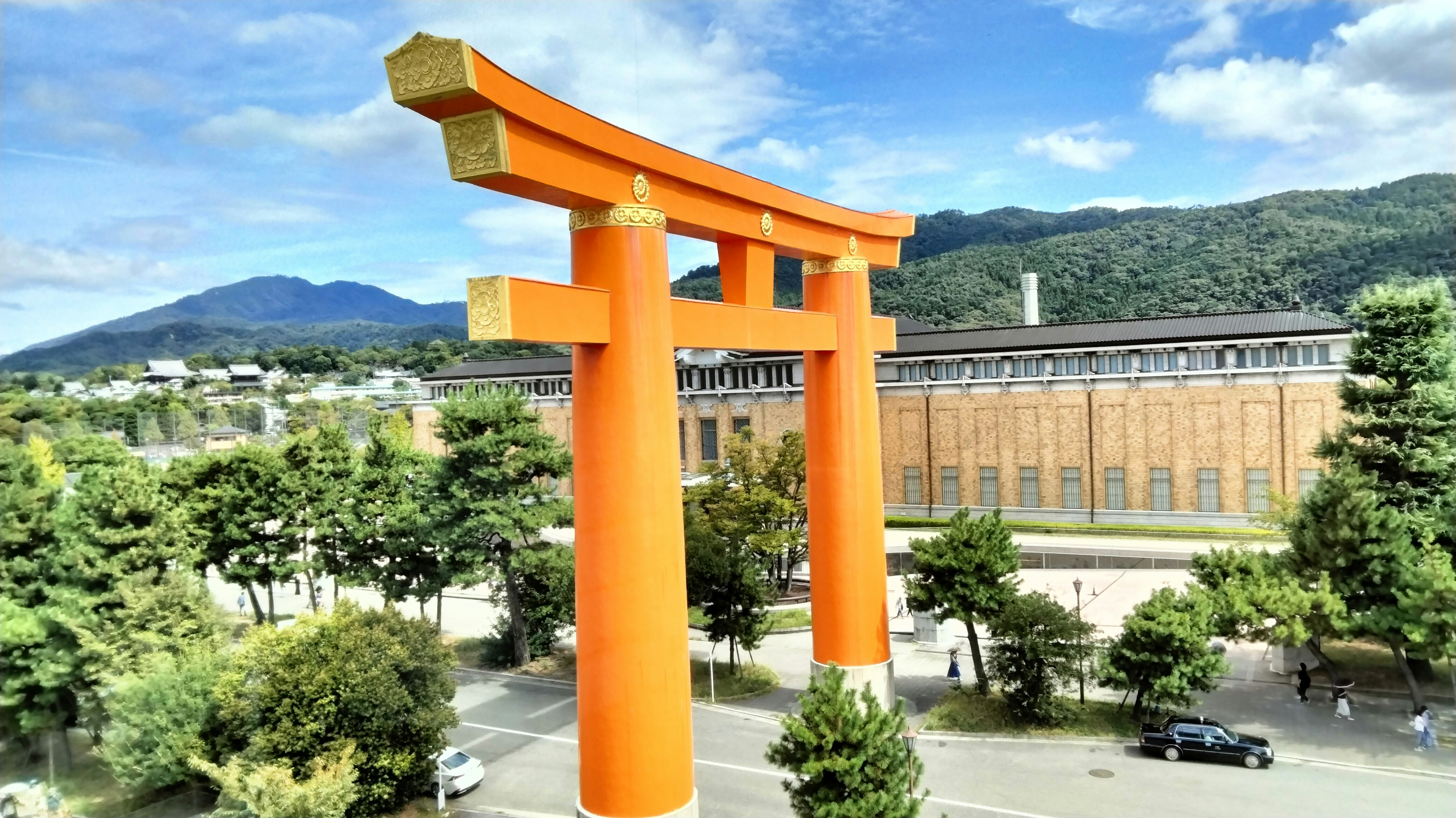 朱色の鳥居と中庭のある寺院風建物の景観