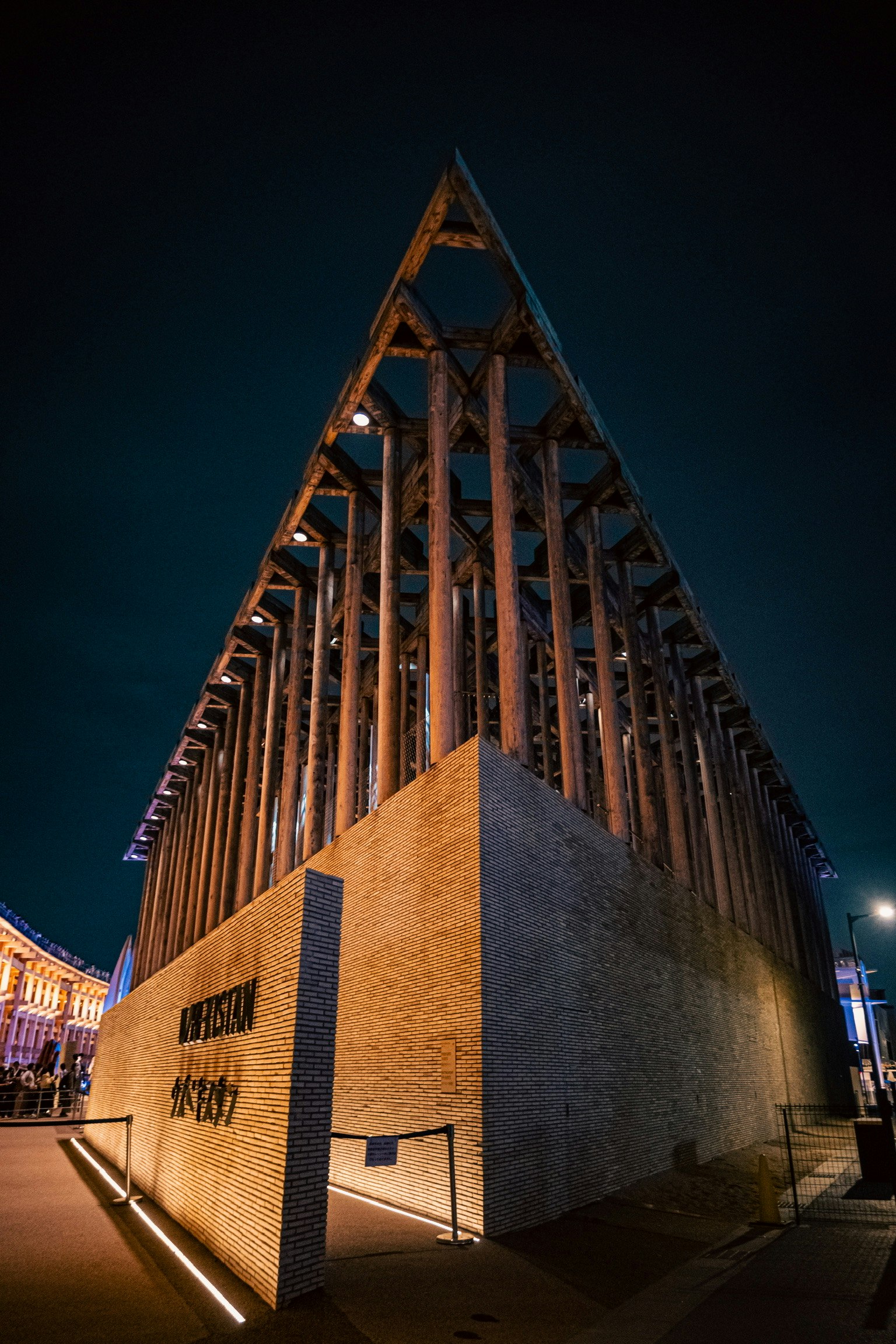 夜の建物の外観 三角形の屋根と木製の柱が特徴