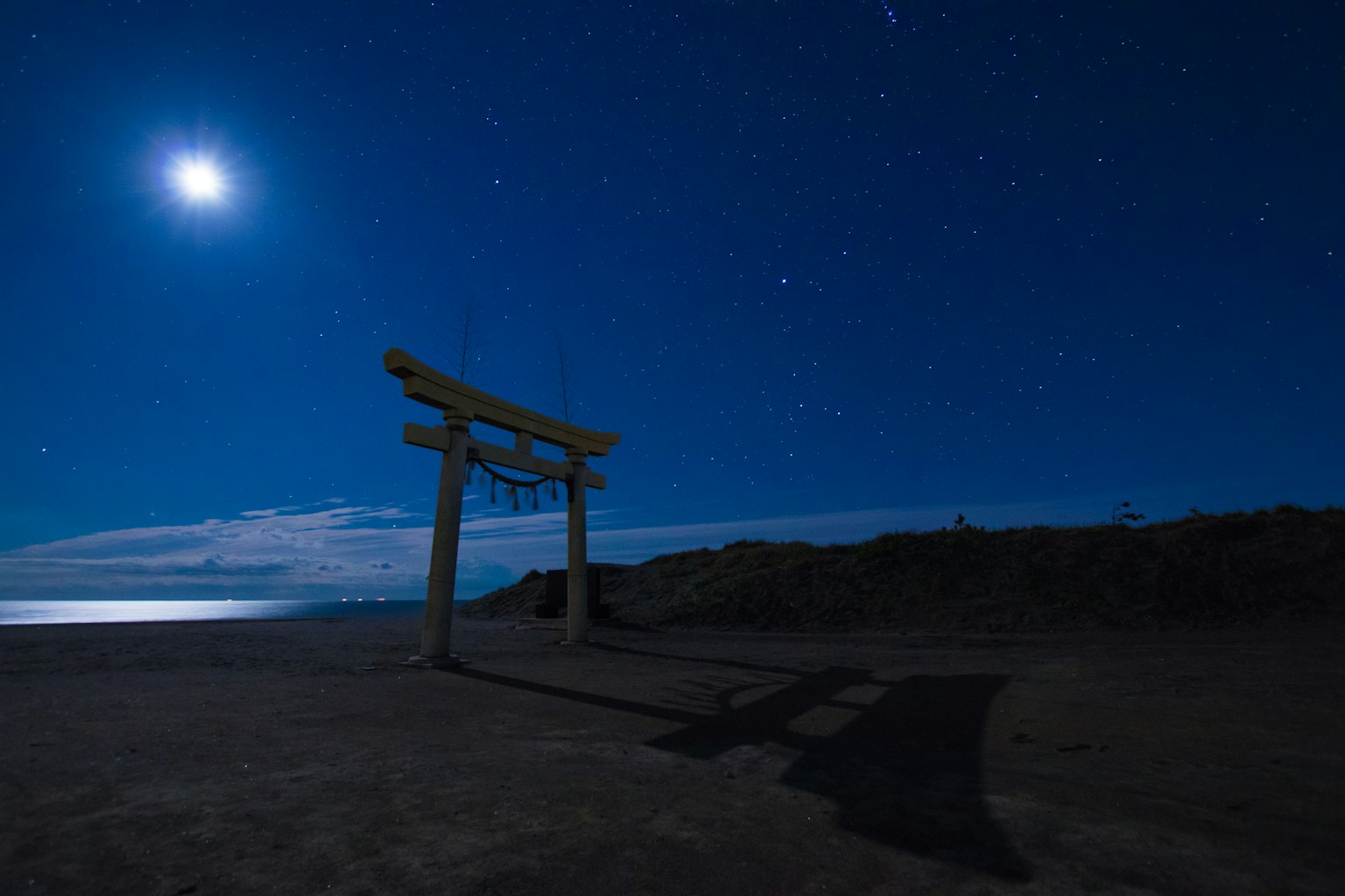 在星空下的鸟居门和明亮的月亮