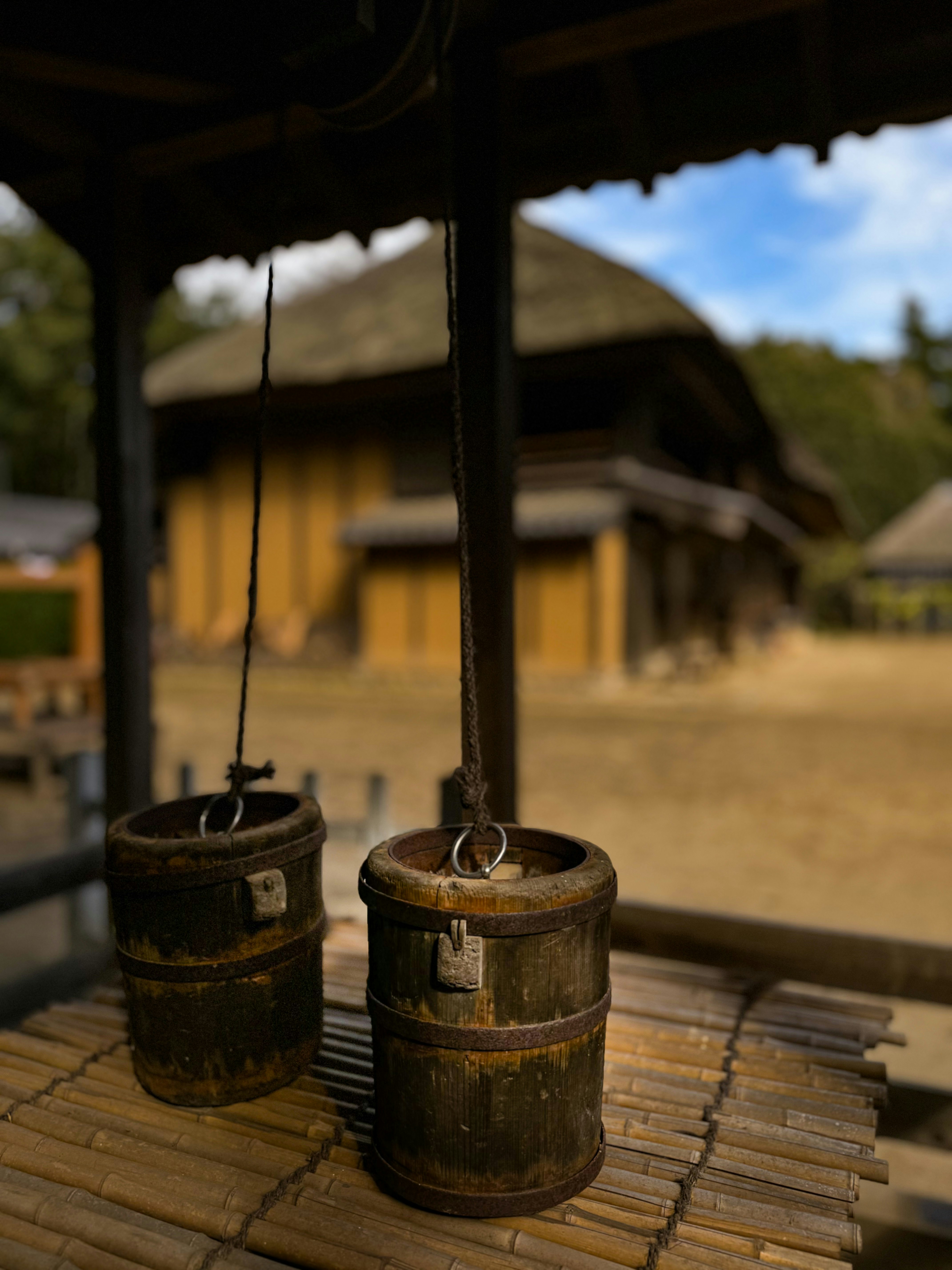 Old wooden barrels and bucket-like containers under an eave