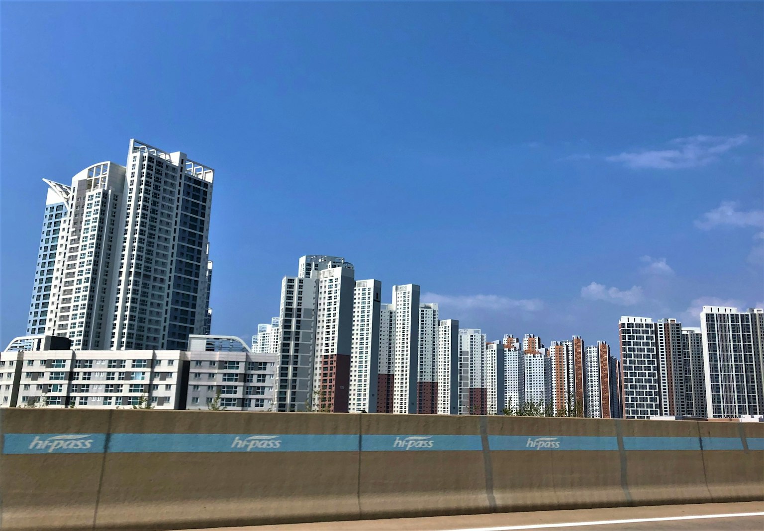 Hochhäuser unter einem blauen Himmel mit einer Straße im Vordergrund