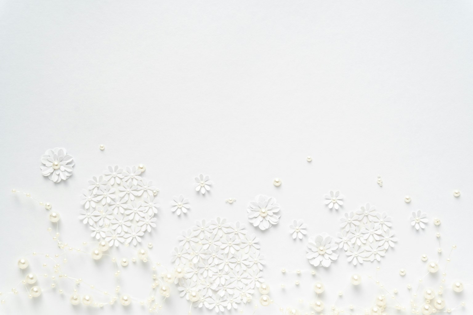 Sfondo bianco con perle bianche e decorazioni a forma di fiore