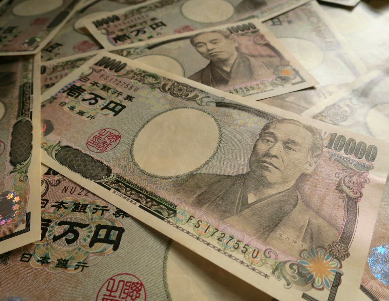 Una collezione di banconote giapponesi da 10000 yen sparse su una superficie