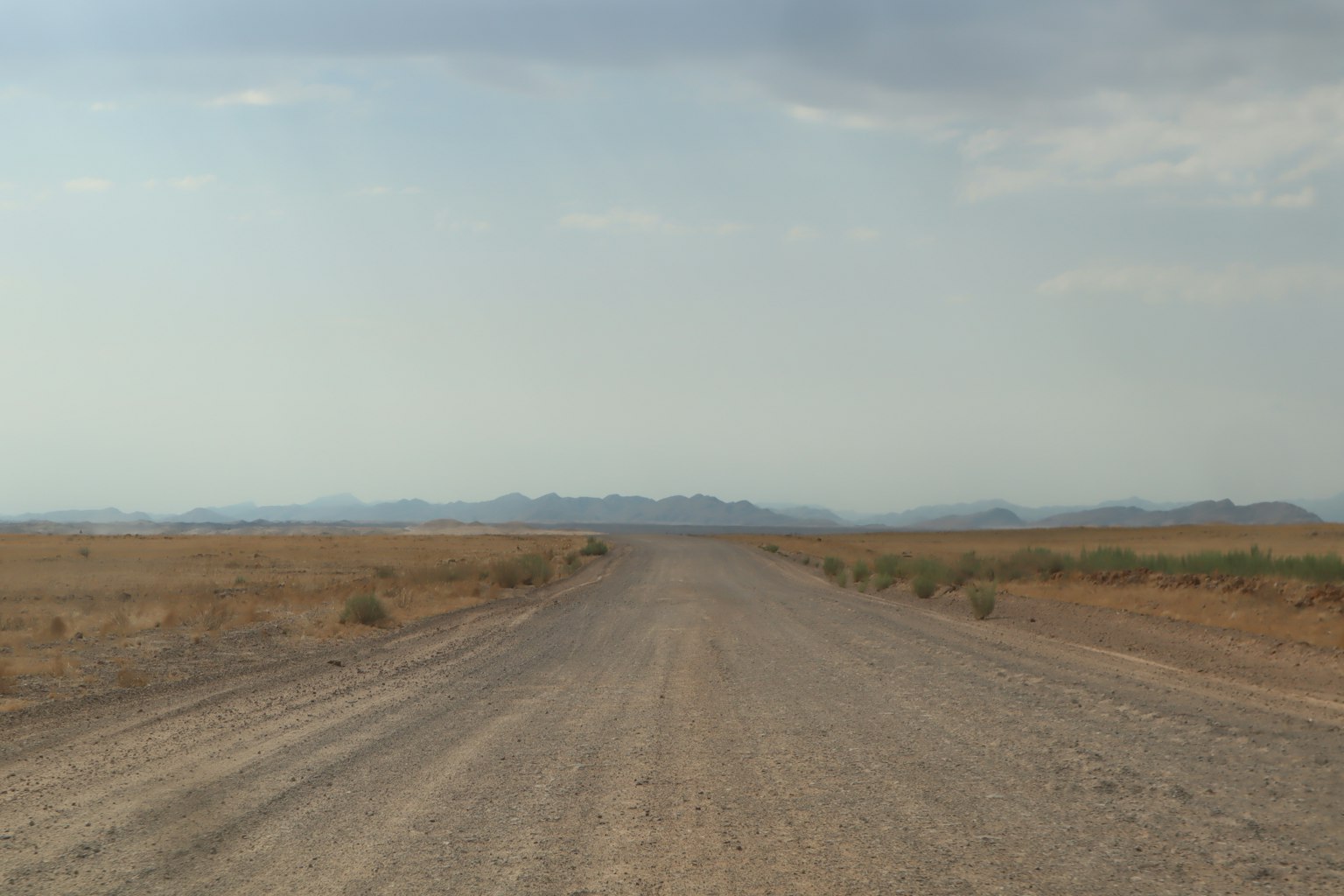 Strada sterrata che si estende in un paesaggio secco