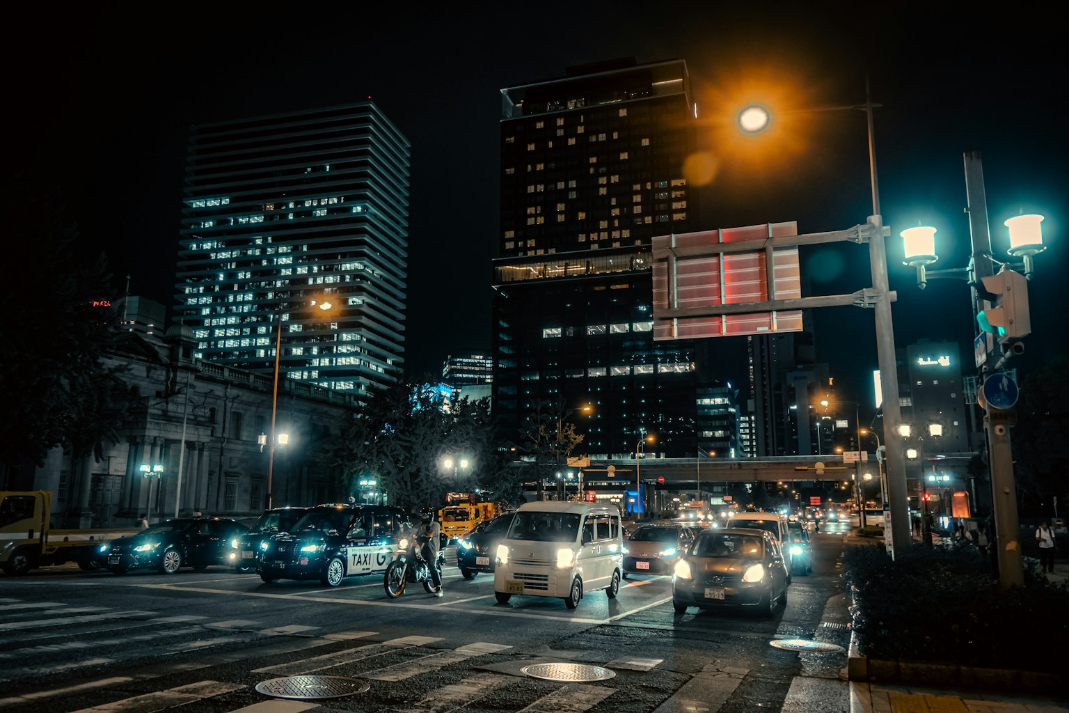 Nächtliche Stadtlandschaft mit beleuchteten Gebäuden Ampeln und Straßenlaternen an der Kreuzung