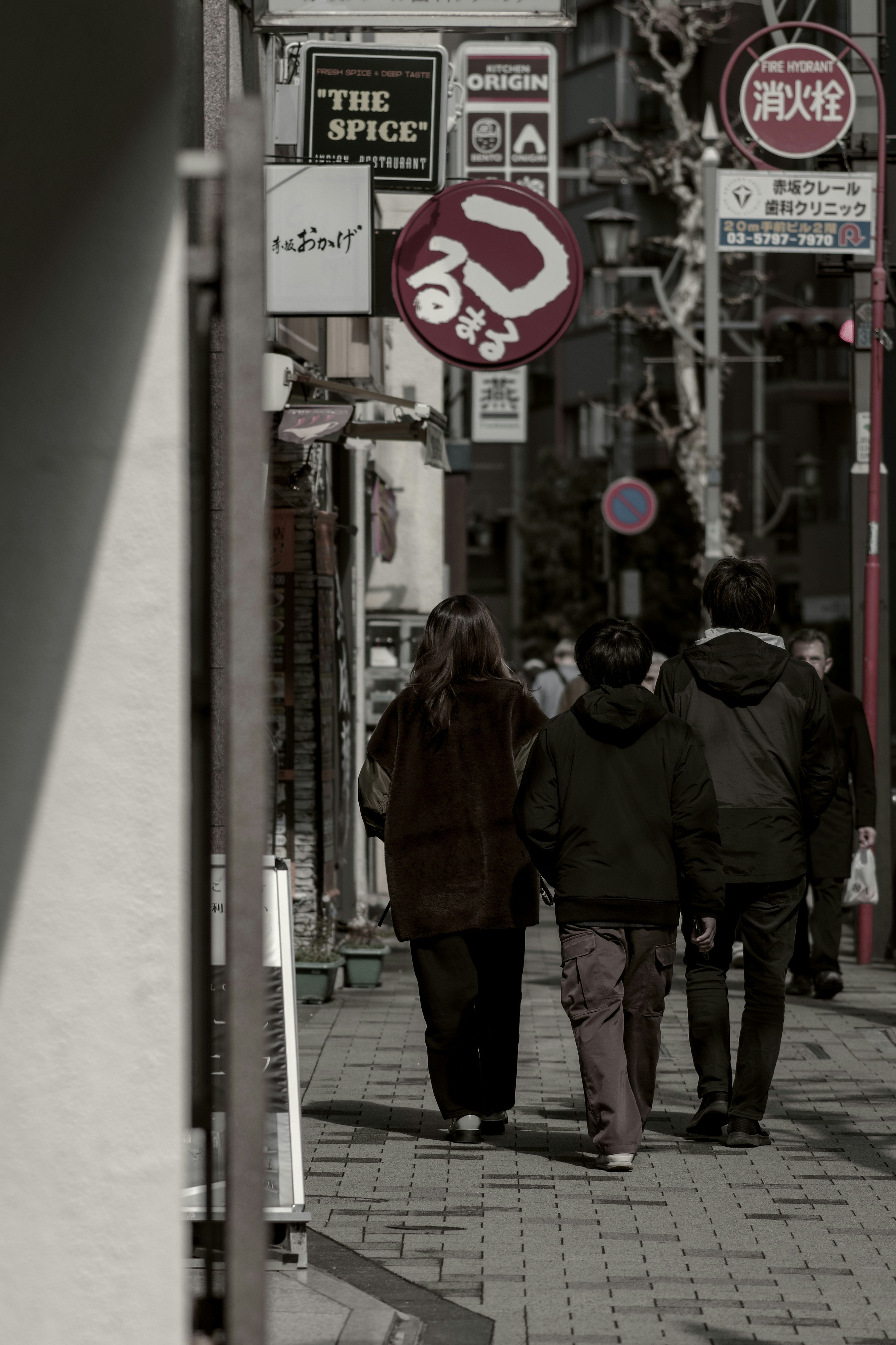路地の看板と人が歩く東京の街並み