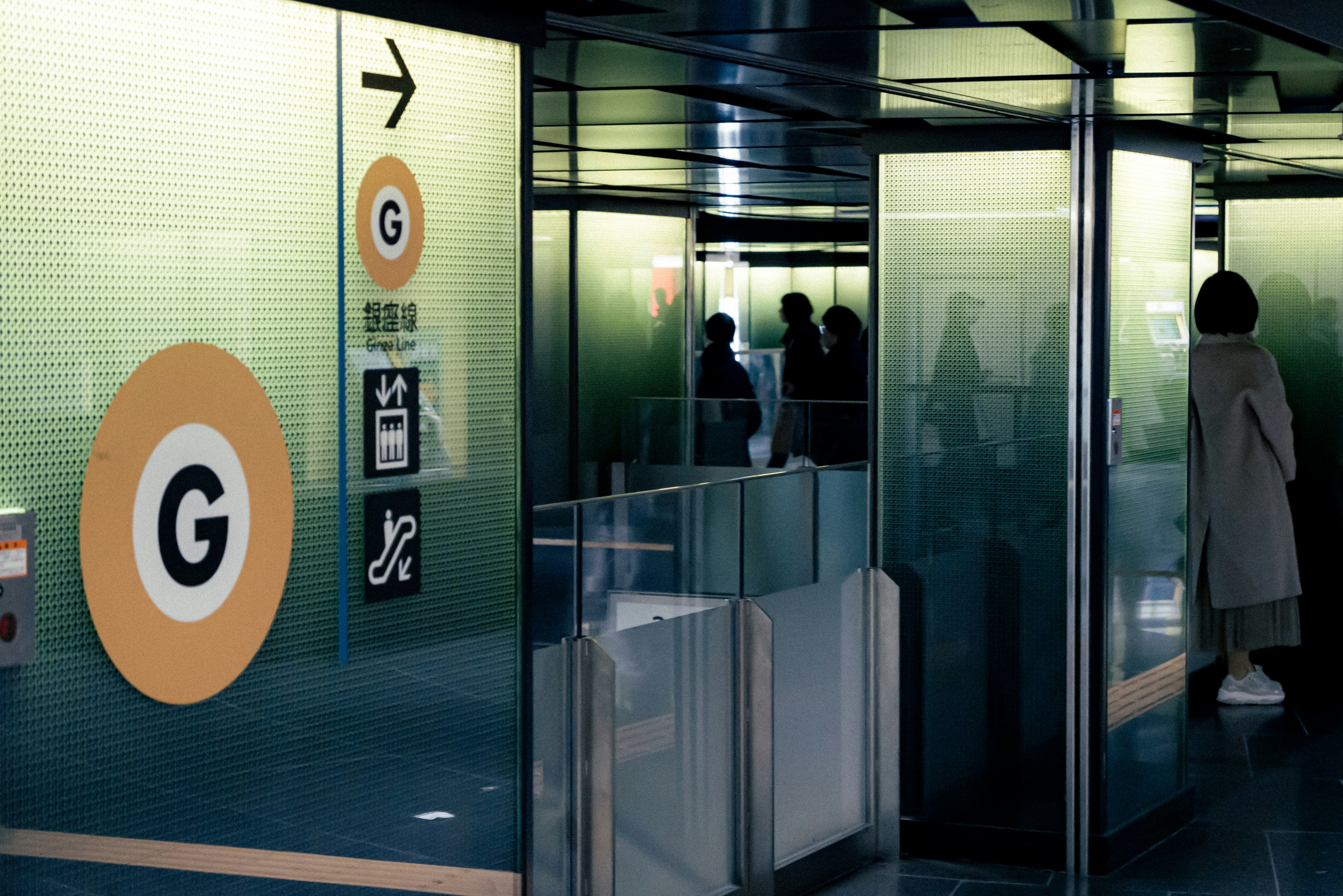 pintu masuk lorong bawah tanah di Ginza dengan gerbang tiket dan orang-orang berjalan