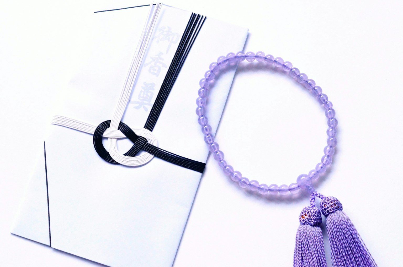 Un joli style avec un bracelet à pampilles violettes et une enveloppe blanche