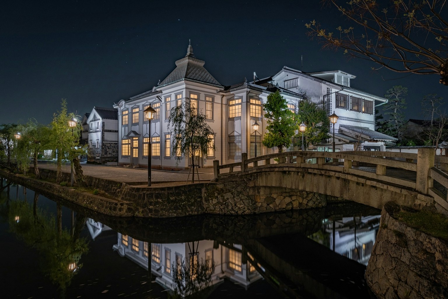 Edificio storico lungo un fiume tranquillo che riflette il bellissimo paesaggio notturno