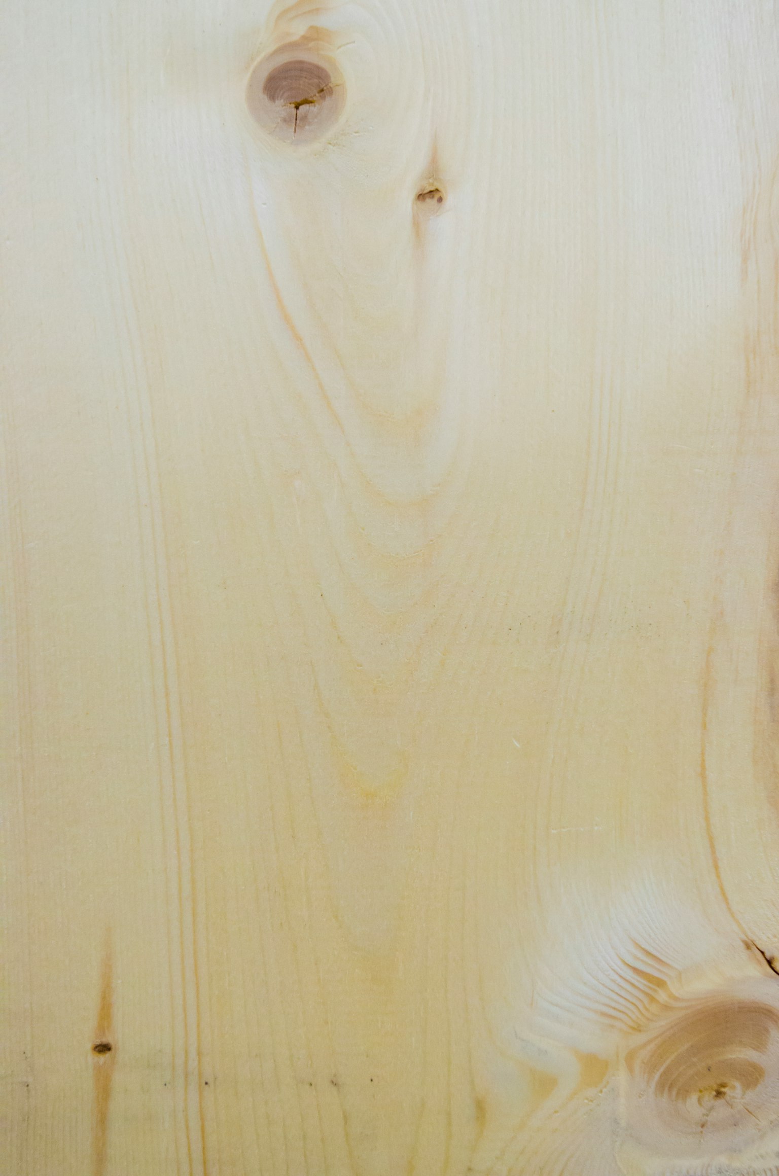 Superficie de madera clara mostrando nudos y patrones de grano