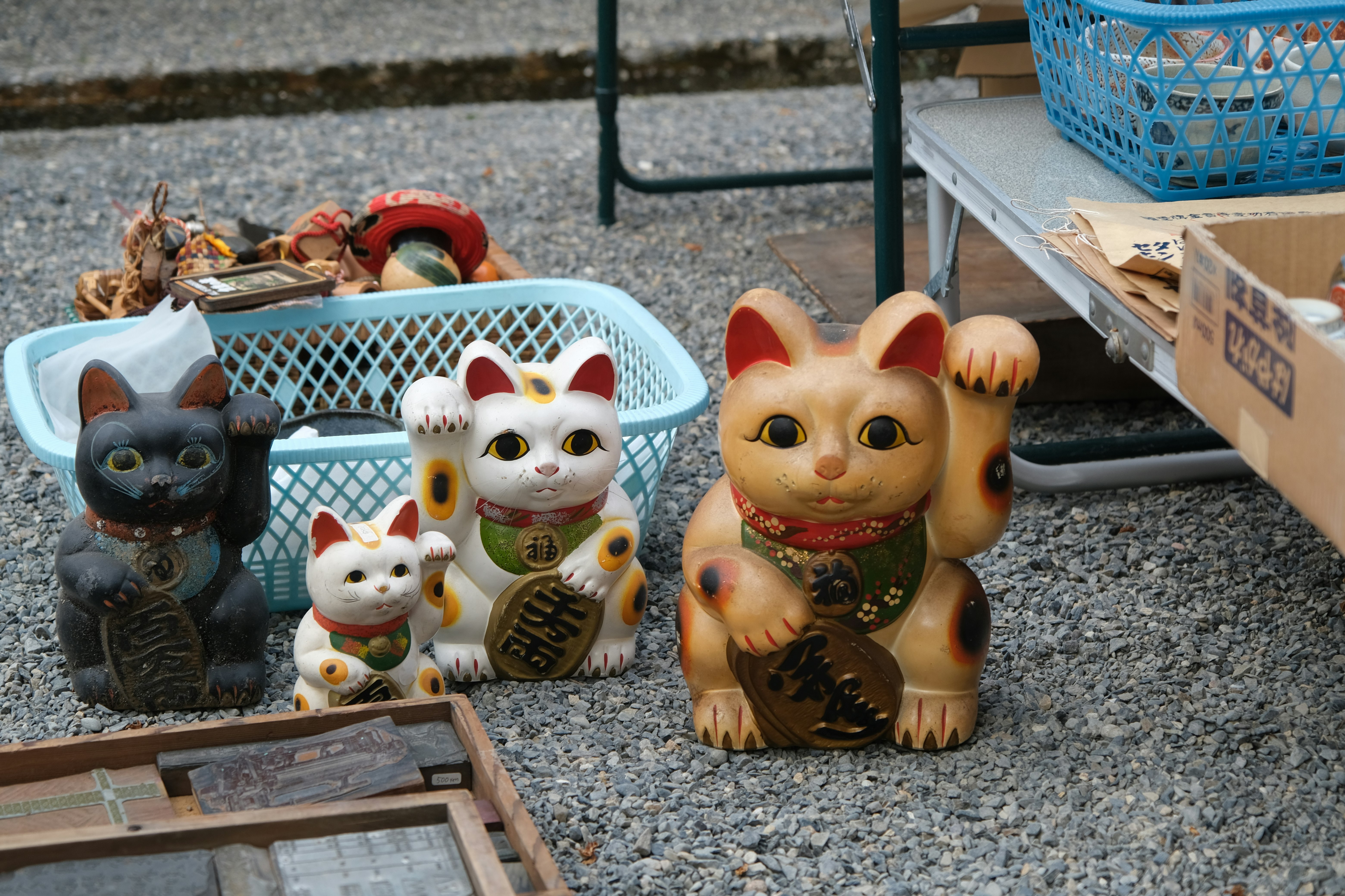 四只不同颜色的陶瓷招财猫在户外展示 黑猫 白猫 小猫 大猫