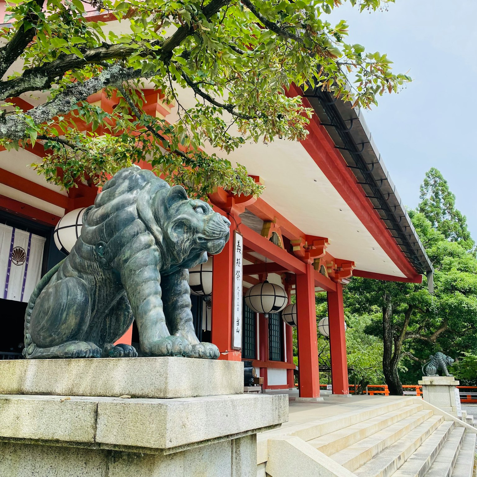 傳統神社前的青銅獅子雕像和紅色裝飾