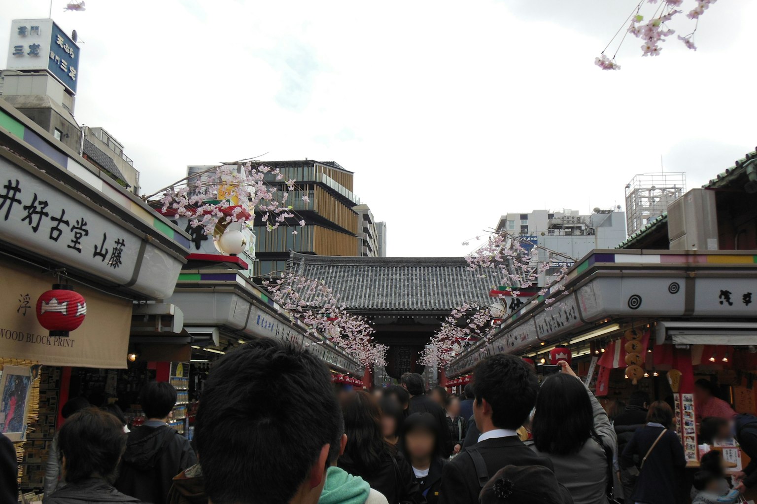 Bustling market street filled with people and cherry blossom decorations