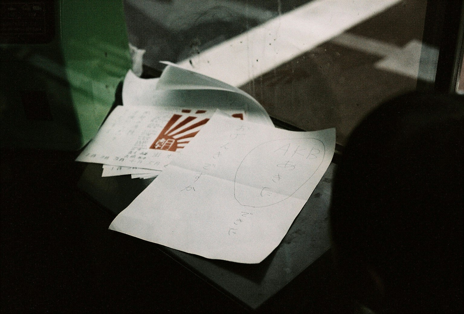 Ein Stapel weißer Papiere in der Nähe eines Fensters mit einem roten Druckdesign