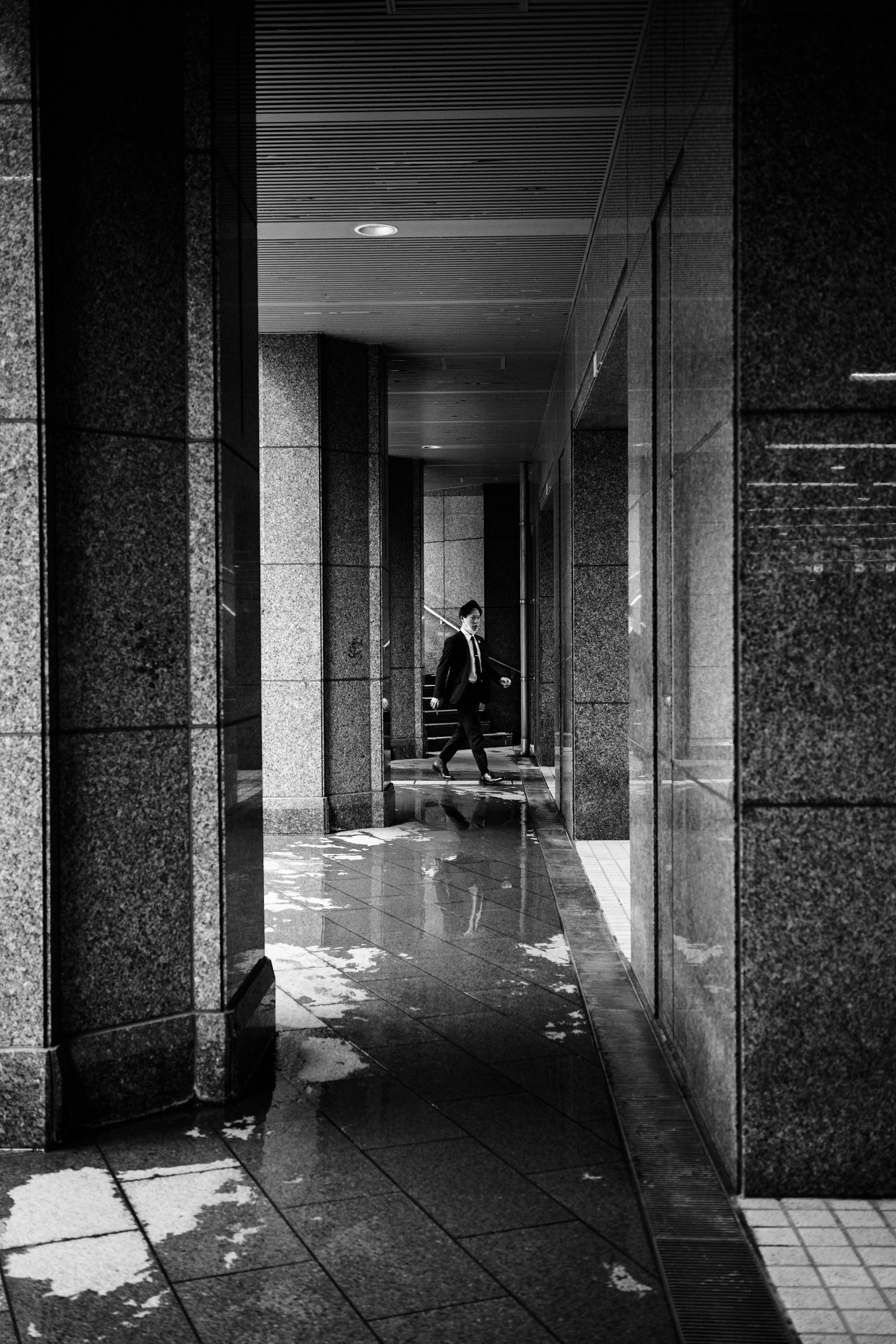 Silhouette di una persona che si trova in un corridoio di città con un forte contrasto bianco e nero