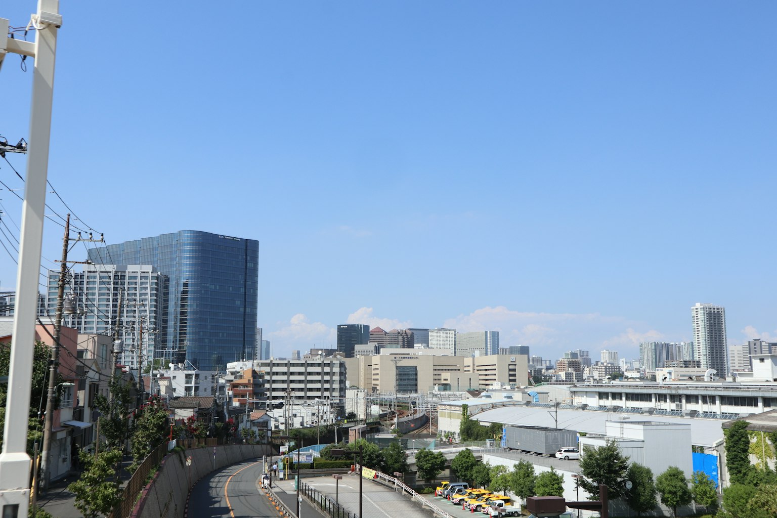 Paysage urbain sous un ciel bleu avec des gratte-ciel et une route sinueuse