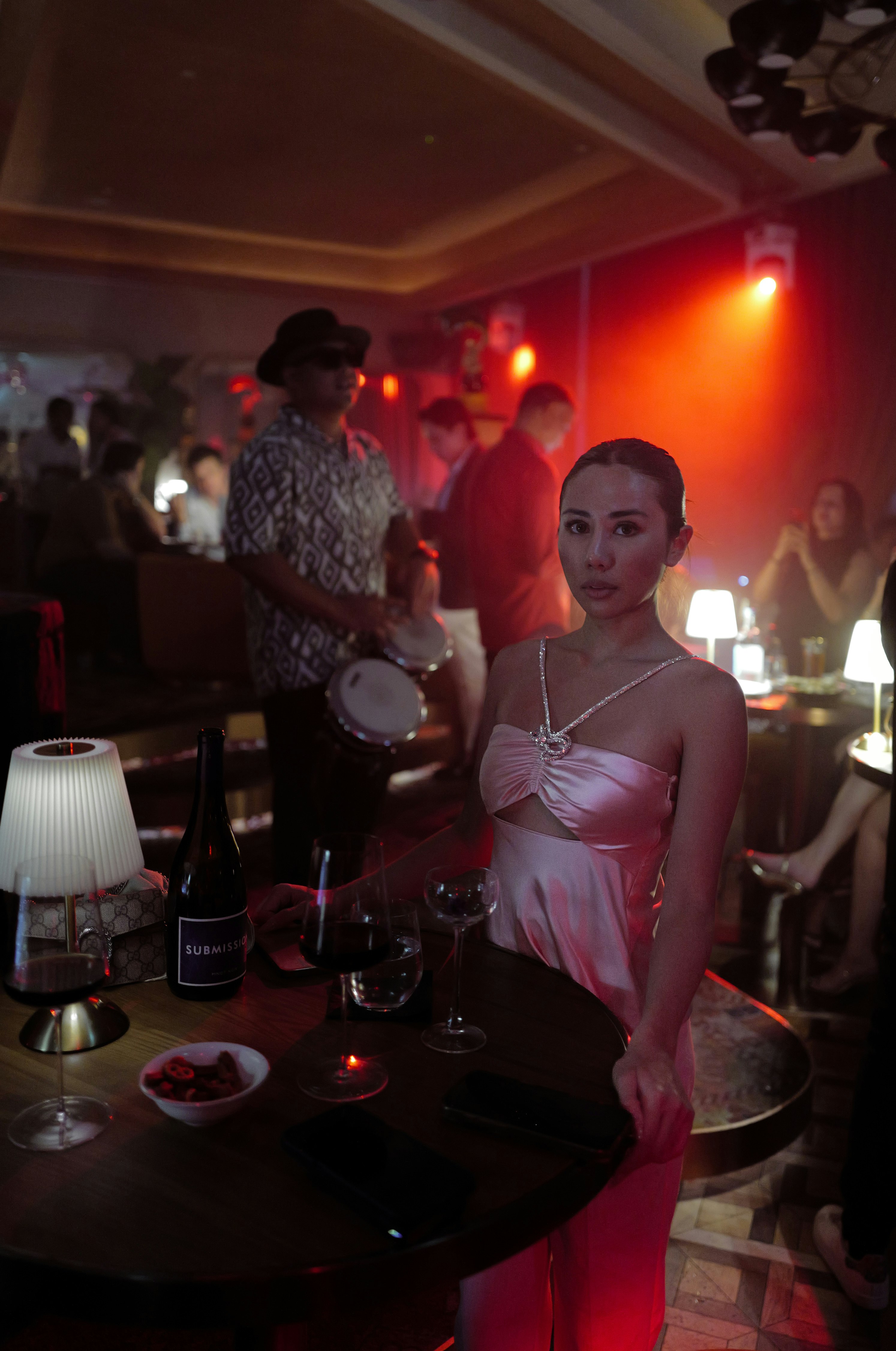 赤いドレスの女性とカクテルグラスが並ぶパーティー会場