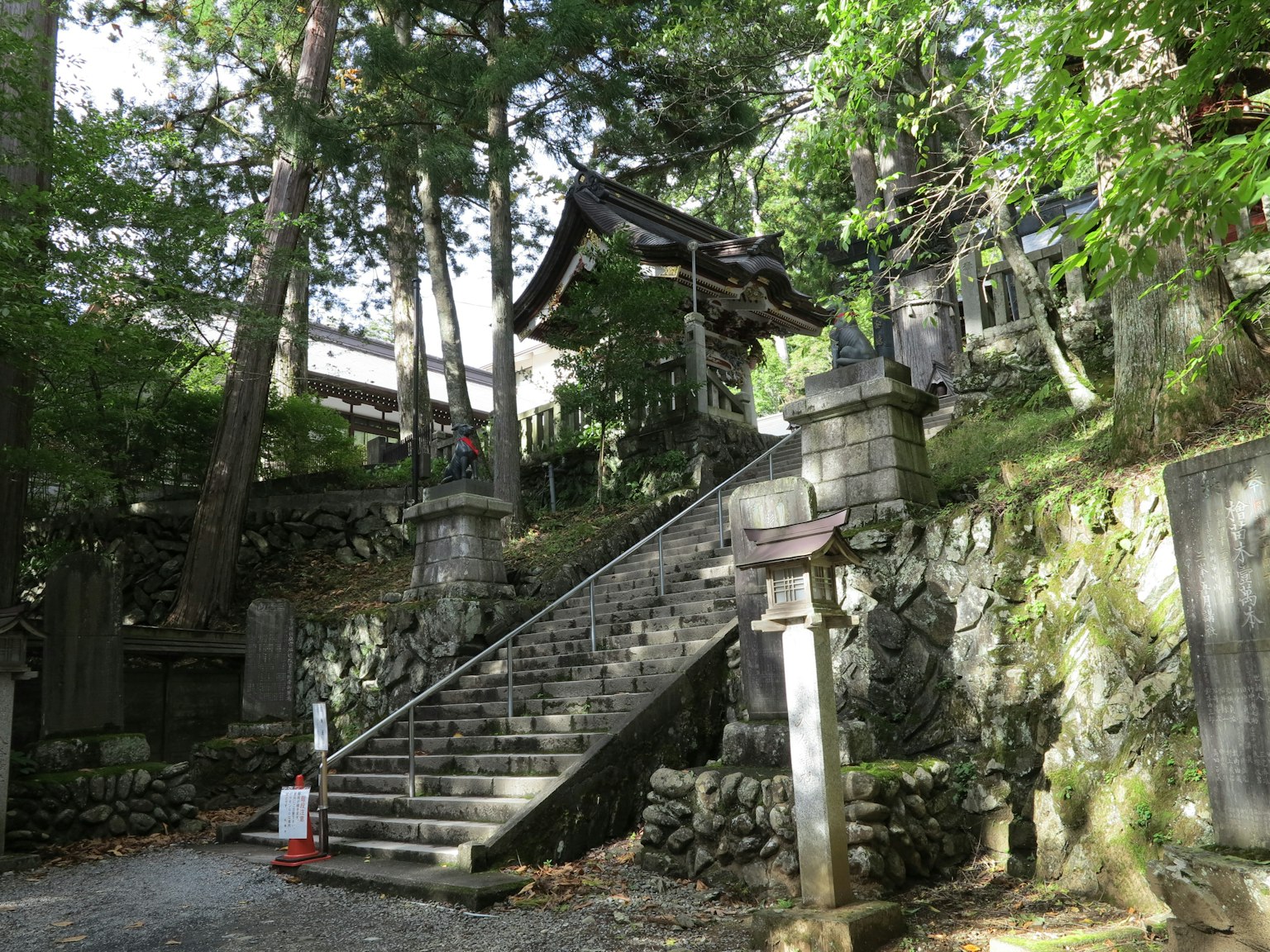 A scenic view of stone steps leading to a shrine surrounded by greenery