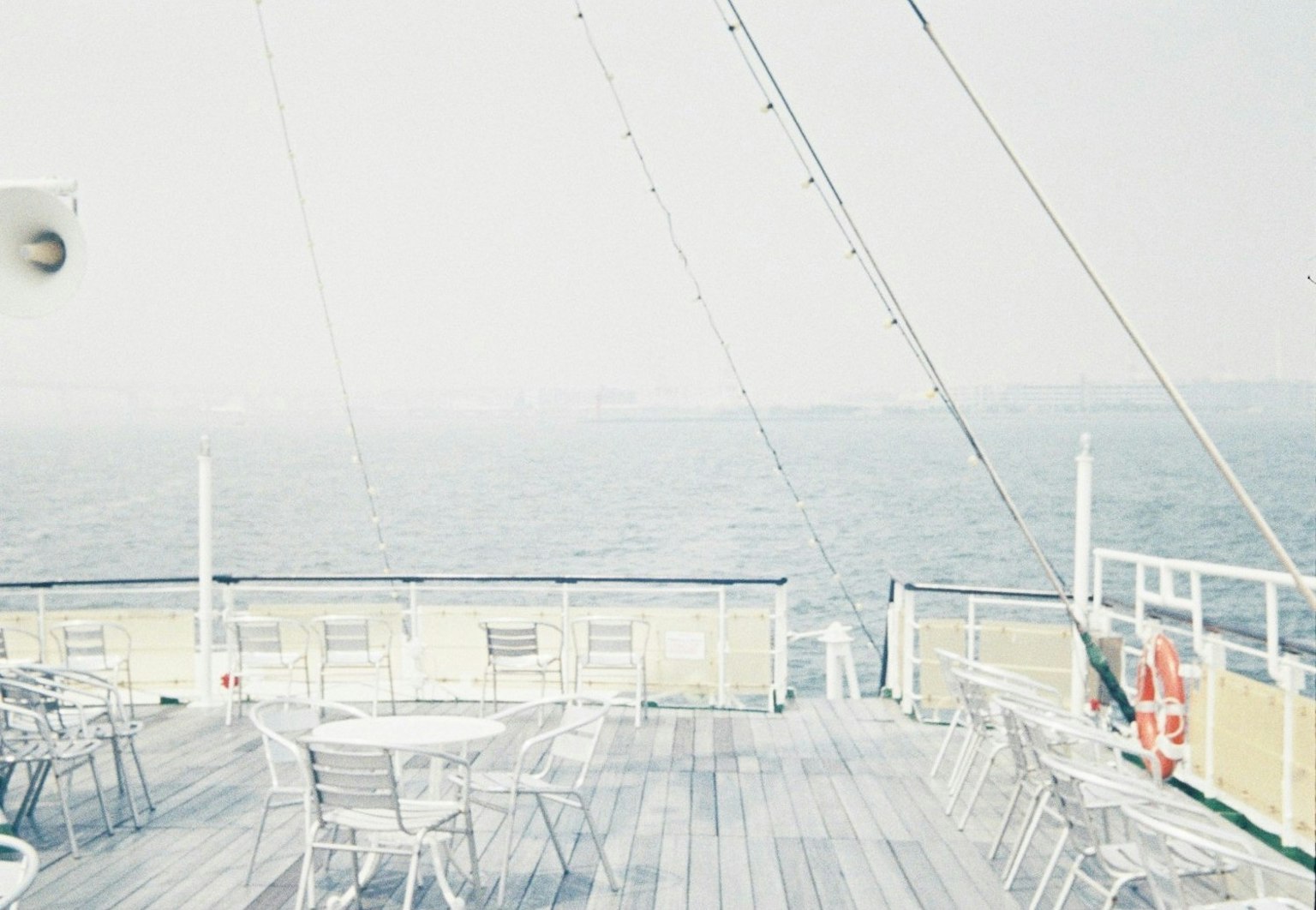 Pont d'un bateau surplombant la mer avec des tables et des chaises