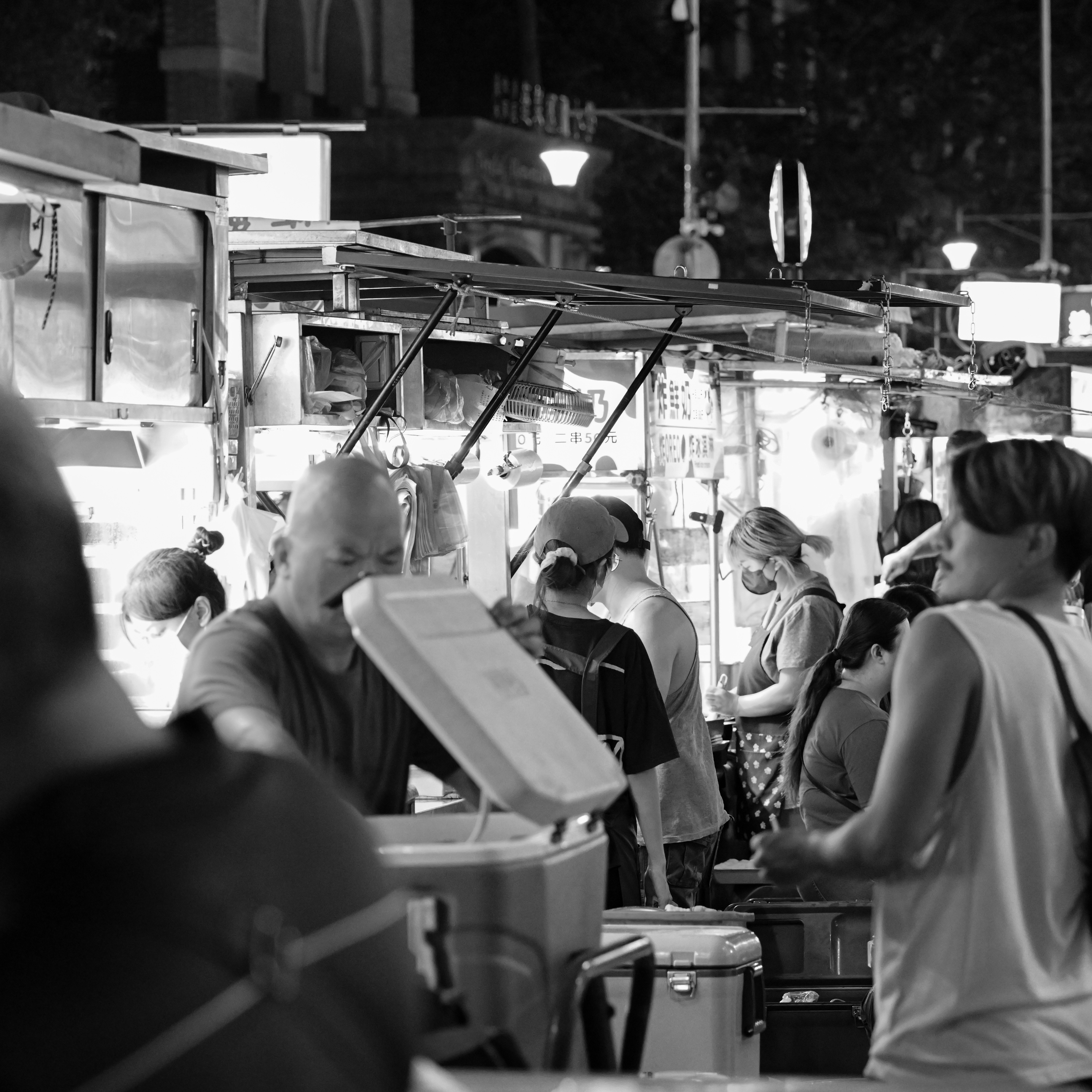 ผู้คนเพลิดเพลินกับอาหารที่ร้านในตลาดกลางคืน